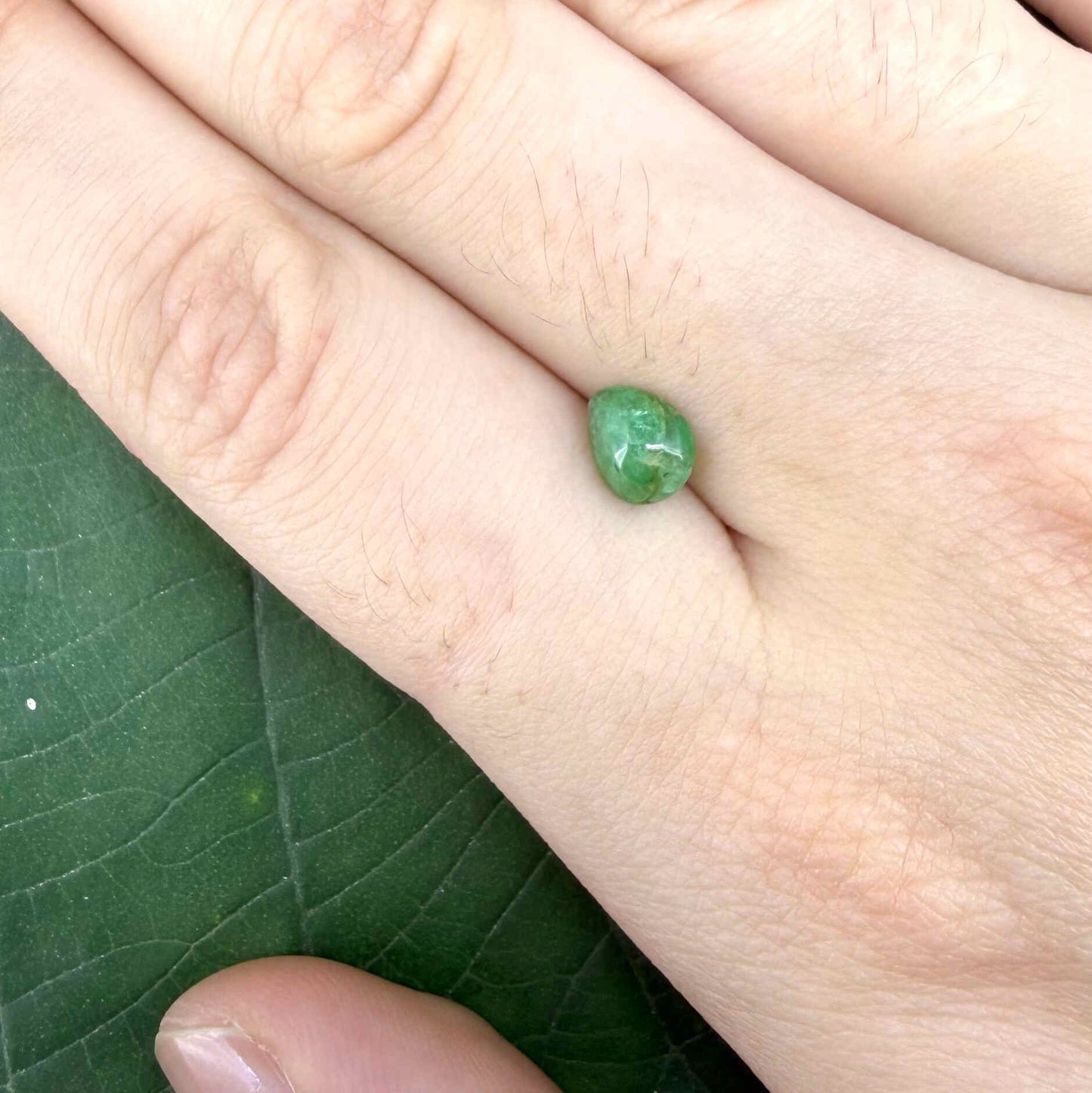 0.75 ct natural untreated emerald from Zambia, one side polished and the other cabochon-shaped.