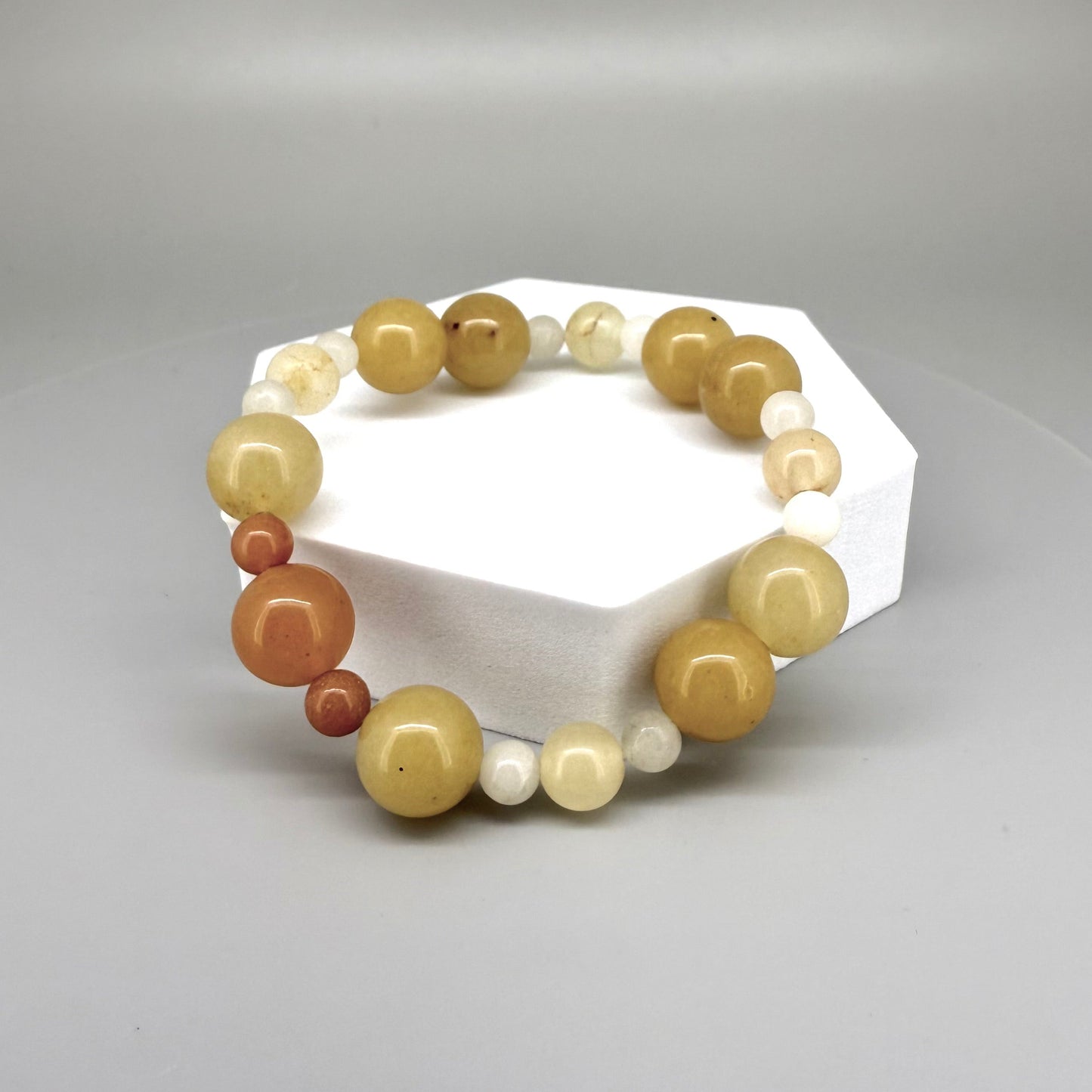 Jade beaded bracelet, 18cm, natural gemstone beads in yellow-cream, orange, and white tones on elastic stretch band.
