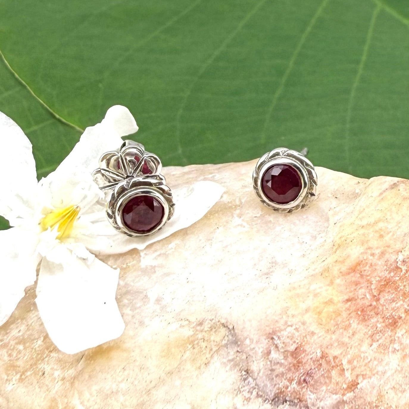 Ruby stud earrings in white gold plated sterling silver with butterfly backs.