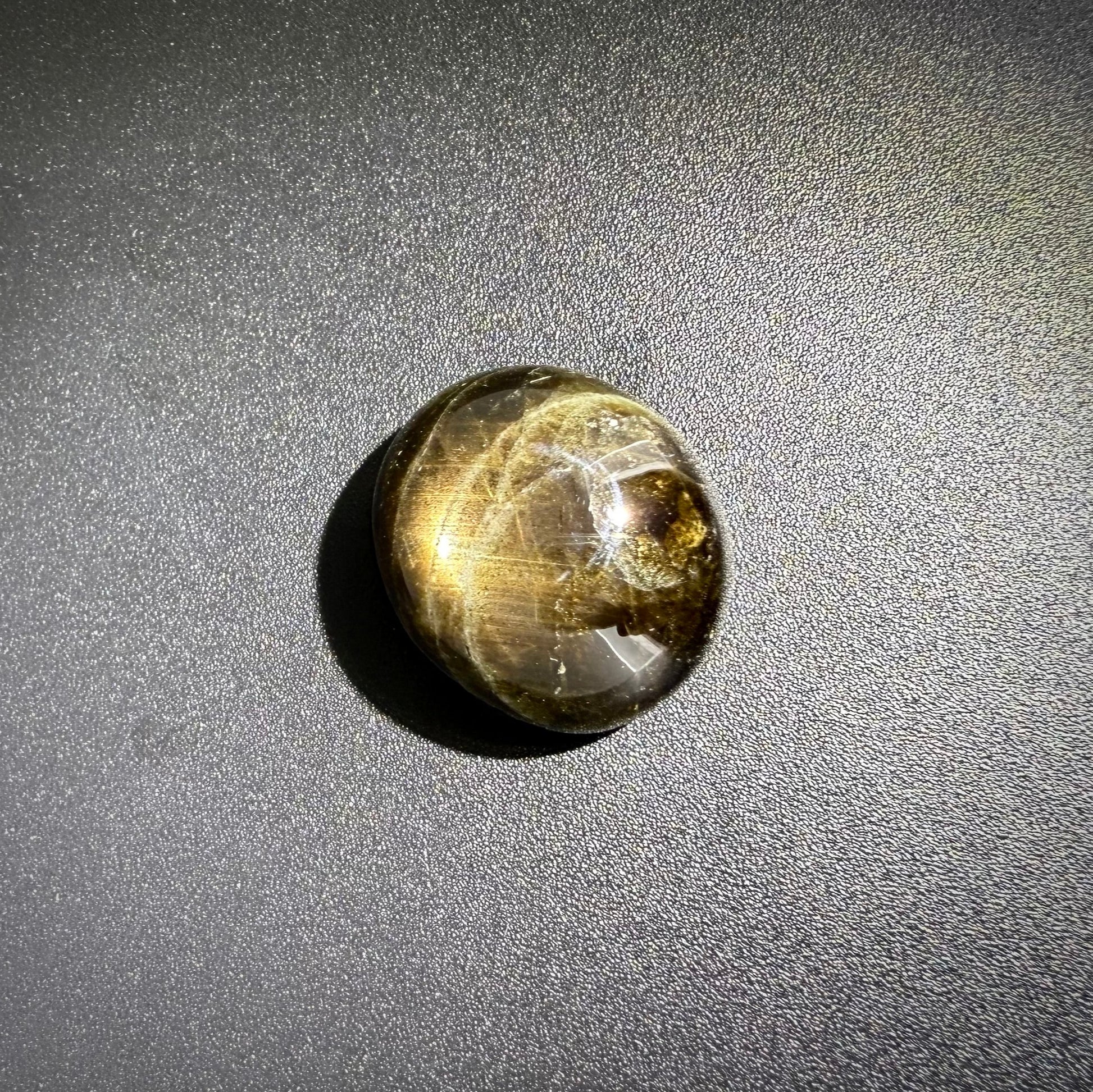 Golden-brown star sapphire cabochon, natural gemstone with subtle asterism
