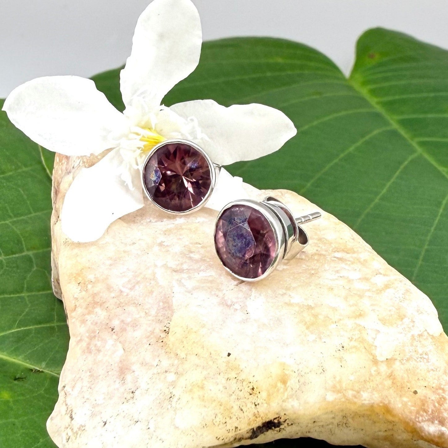 White gold plated sterling silver stud earrings featuring round-cut rhodolite garnets in a classic setting.