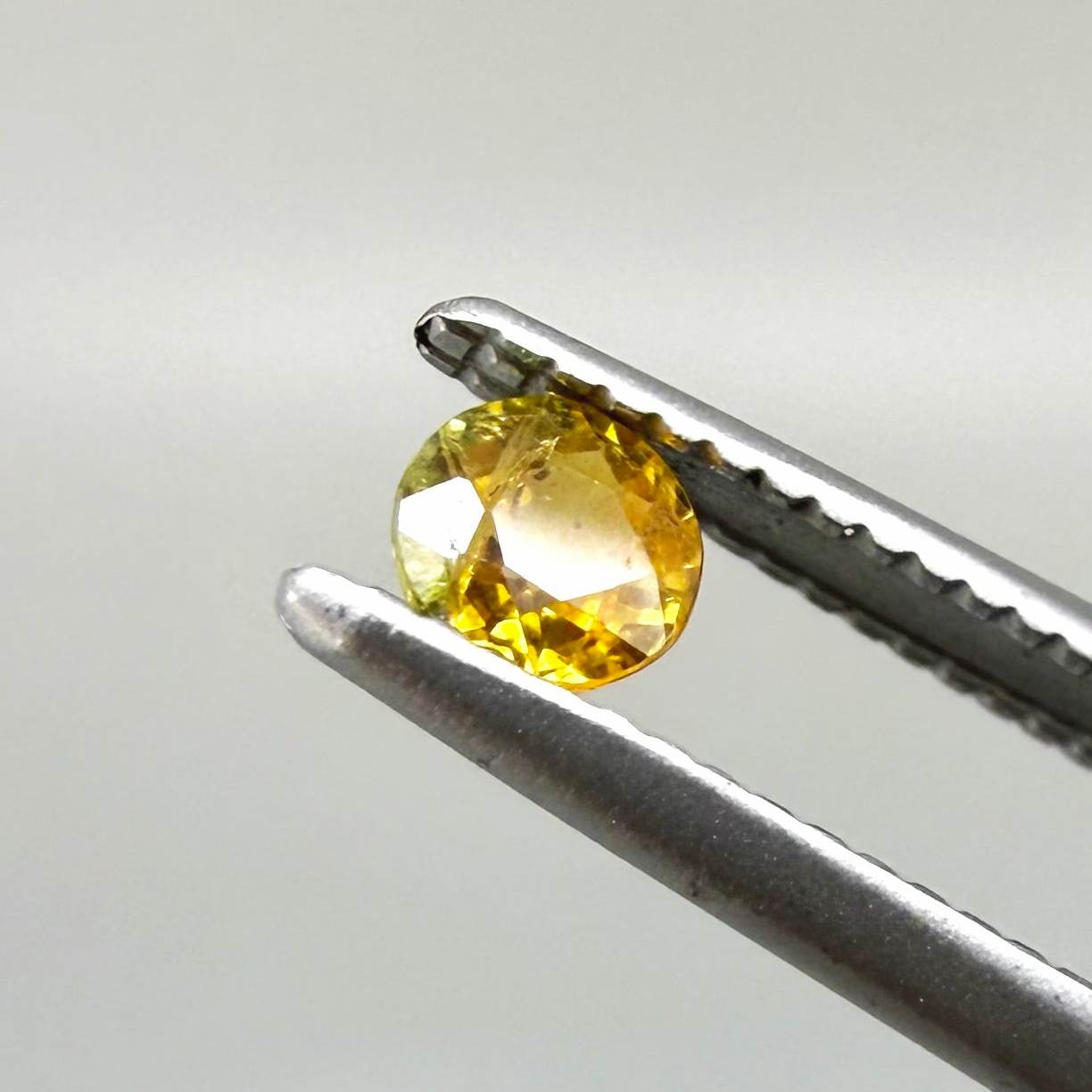 0.2 ct natural orange sapphire from Bangkaja, round cut.