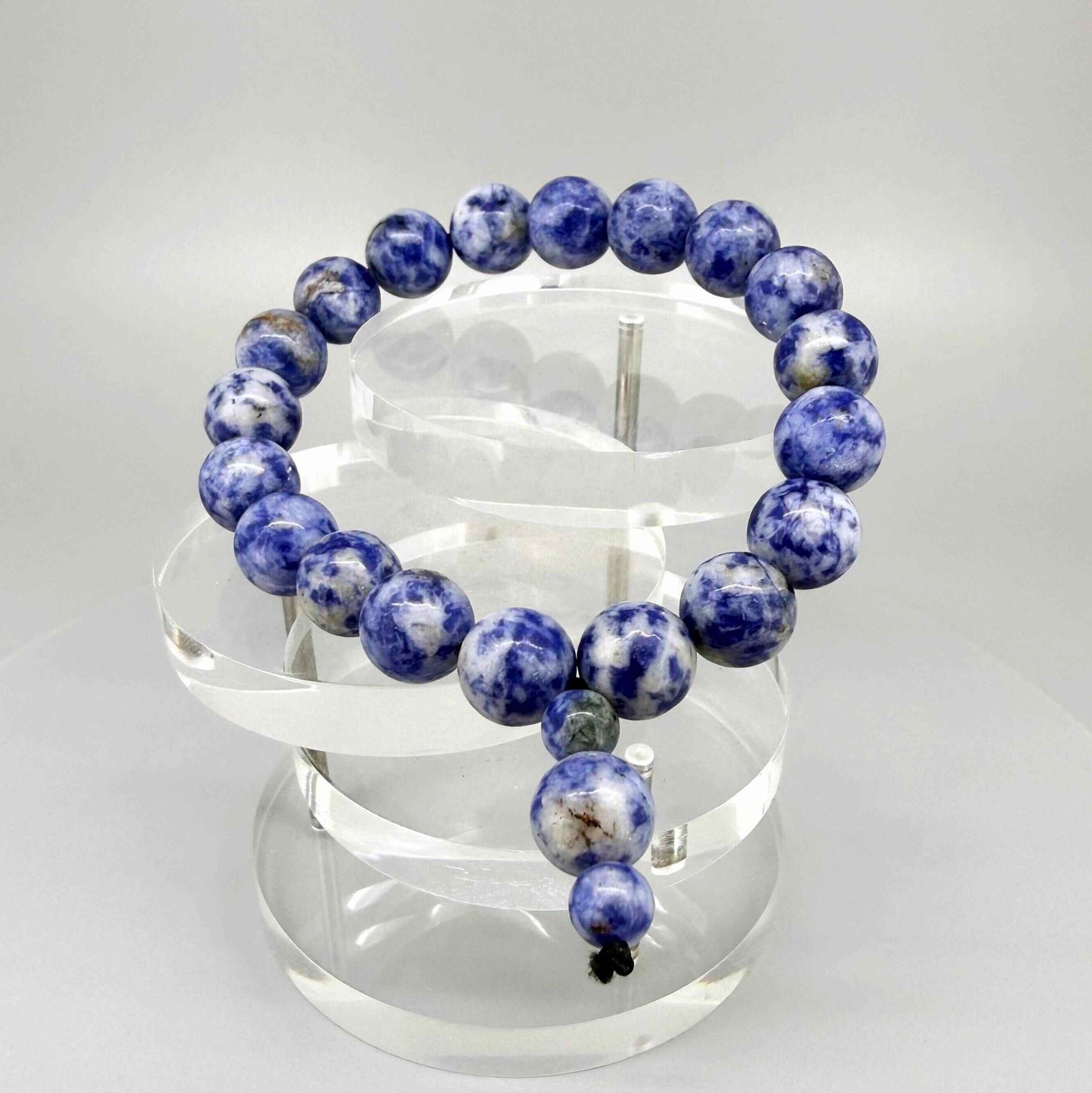 Blue Jasper mala bracelet with marbled blue and white natural gemstone beads and decorative charm detail.