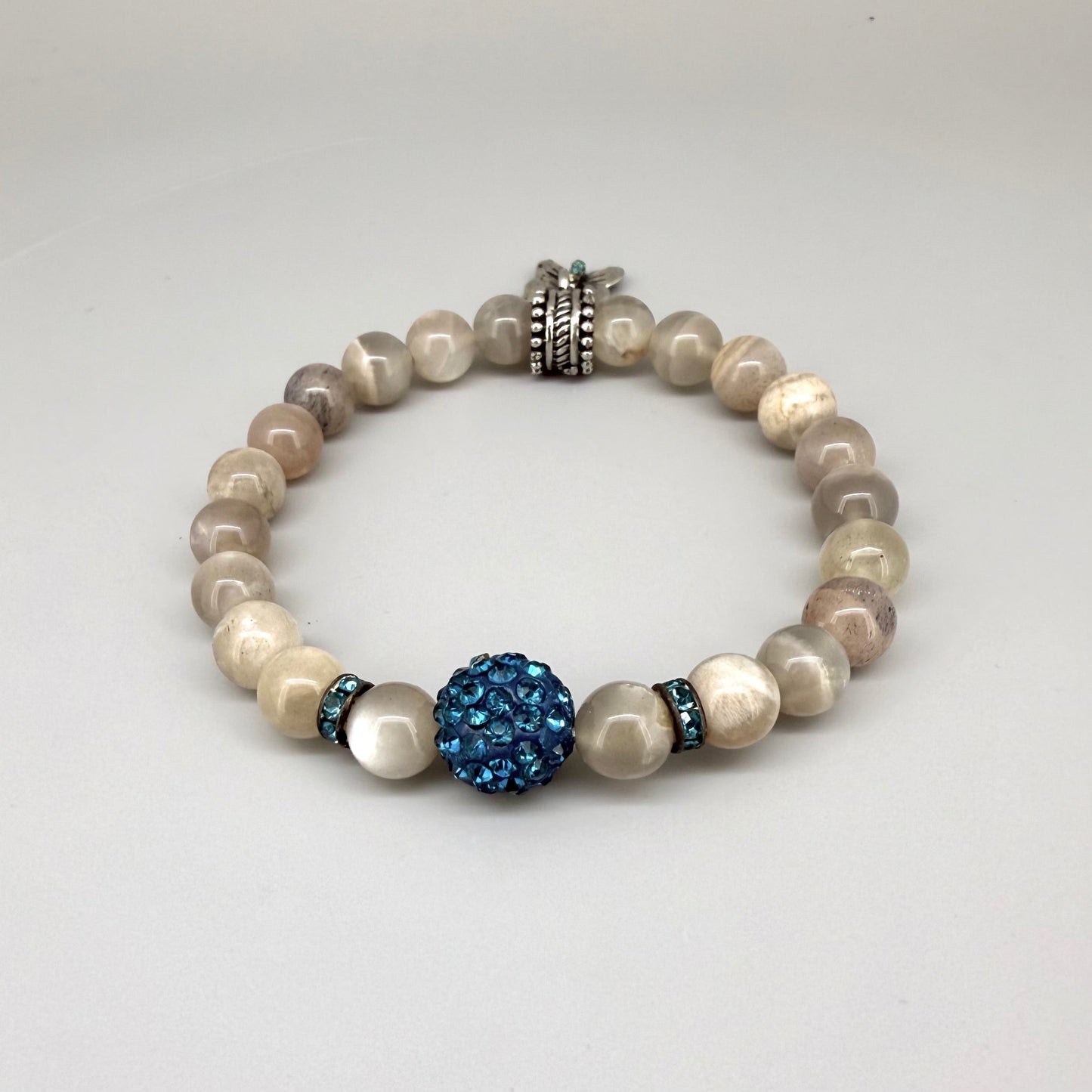 Moonstone beaded bracelet, 19cm, beige earthy gemstone beads with blue decorative bead and silver butterfly charm on elastic stretch band.