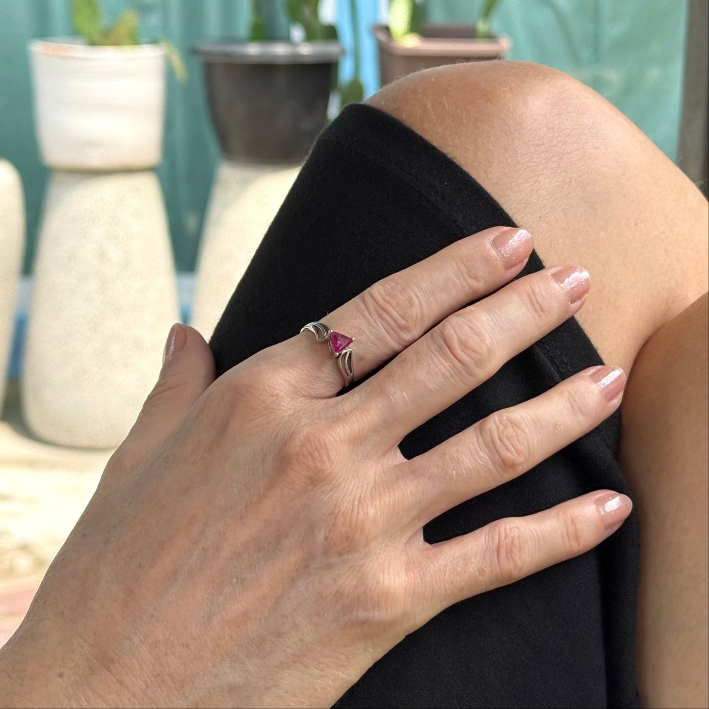 Ruby triangle-cut ring in white gold plated sterling silver, featuring a vivid red natural gemstone in a modern geometric solitaire design.