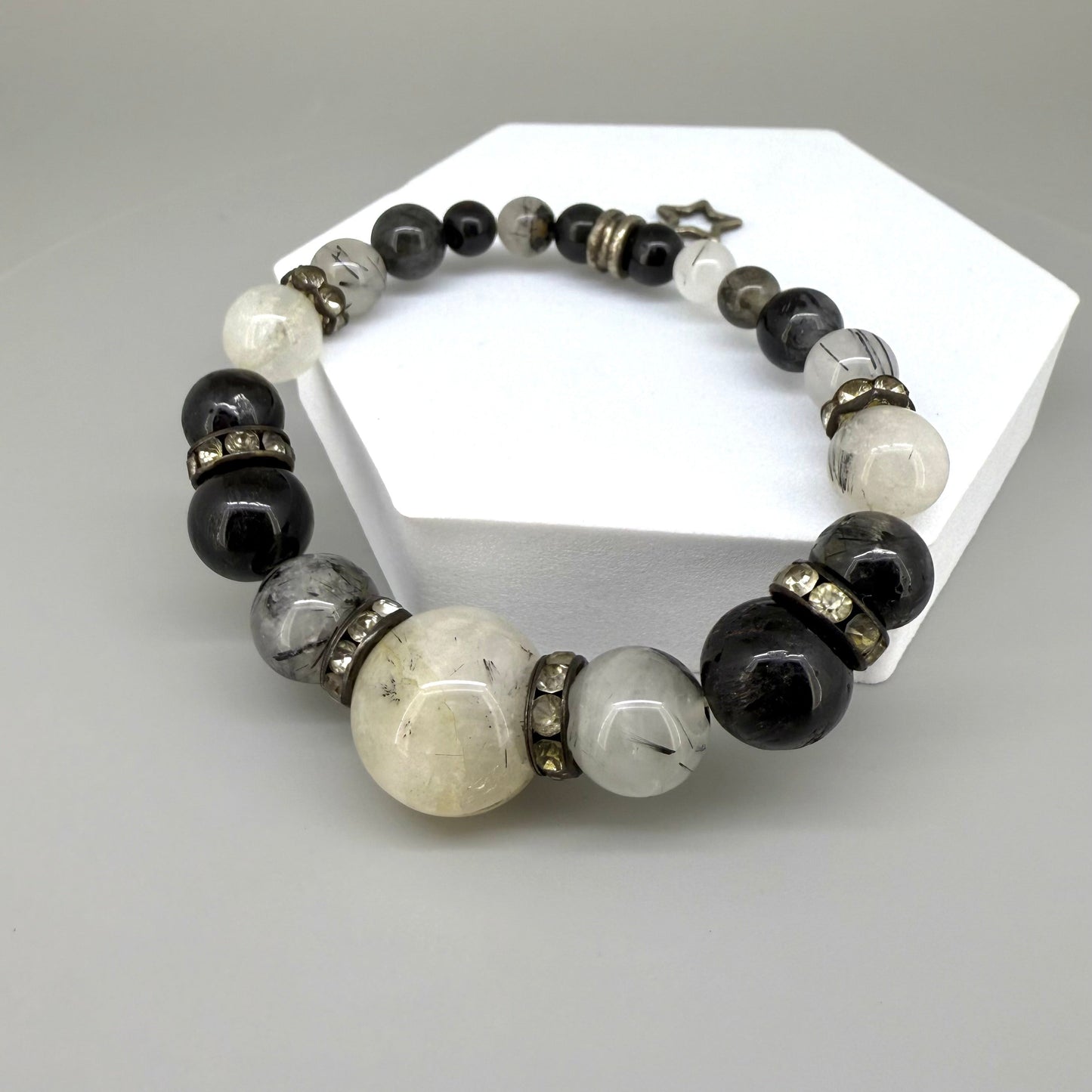 Rutilated quartz beaded bracelet, 18cm, black rutile inclusions with larger light bead and star charm on elastic stretch band.