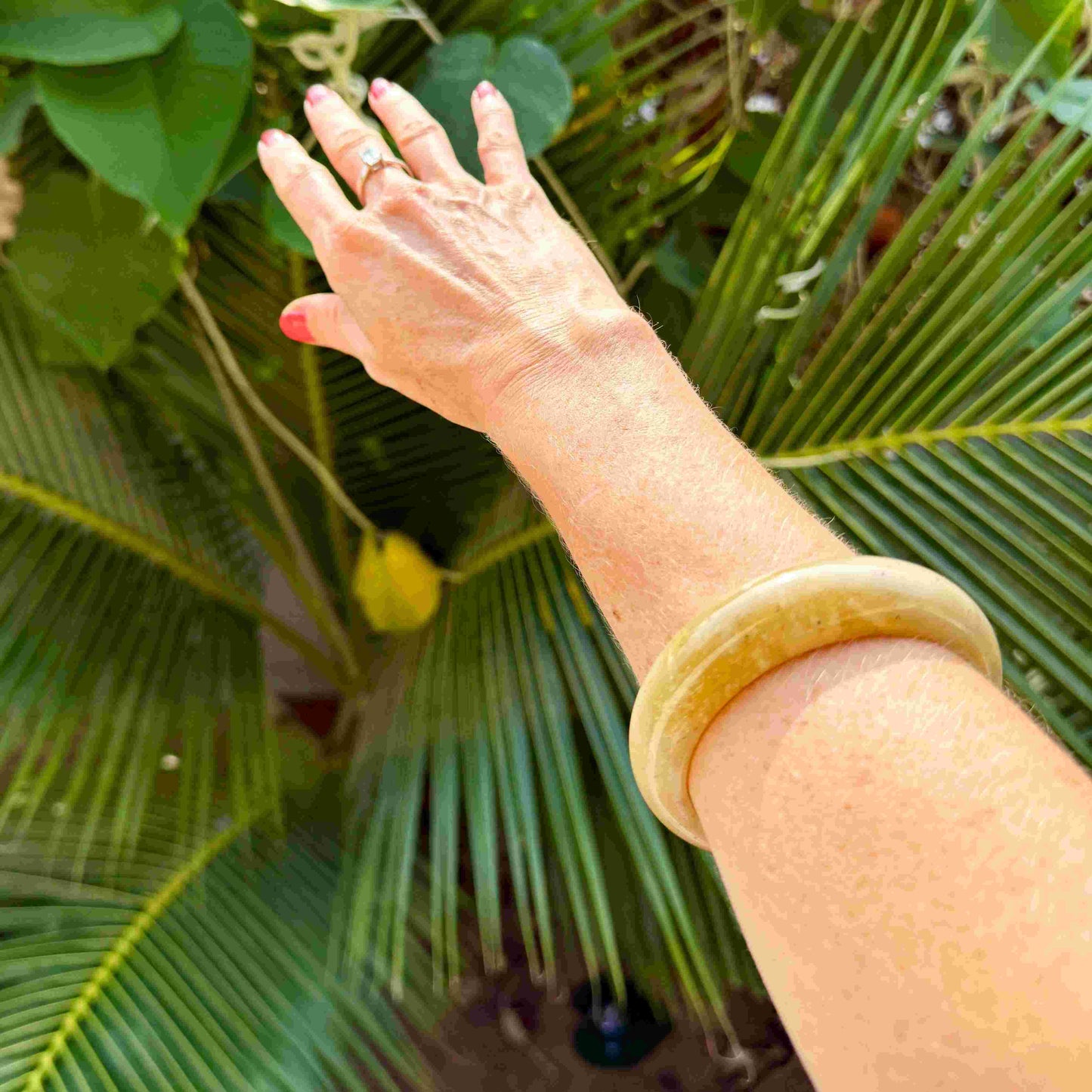 Polished jade bangle in soft earth tones with smooth surface and natural variations