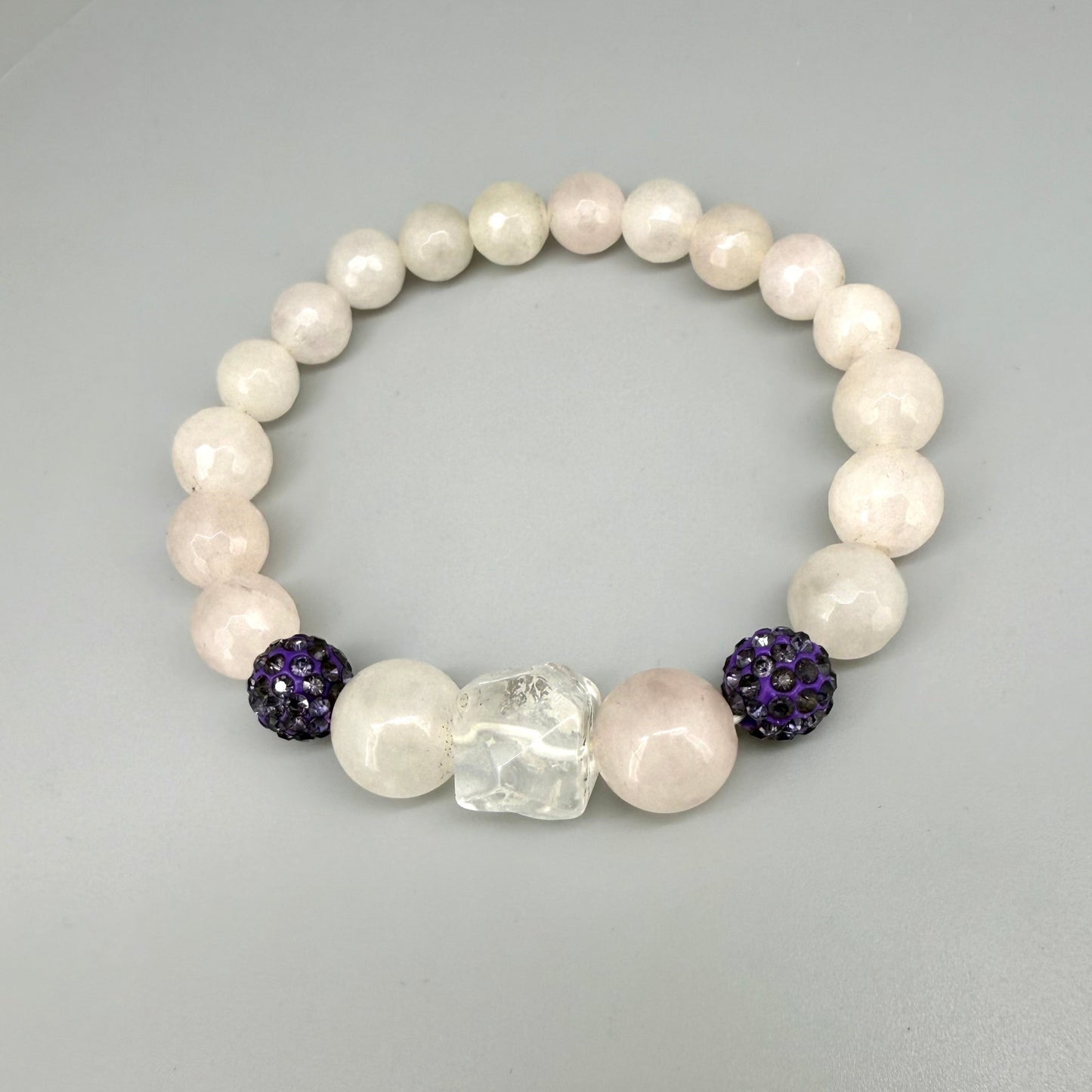Rose quartz beaded bracelet, 19cm, light pink gemstone beads with larger central rose quartz bead and black sparkling accent beads on elastic stretch band.