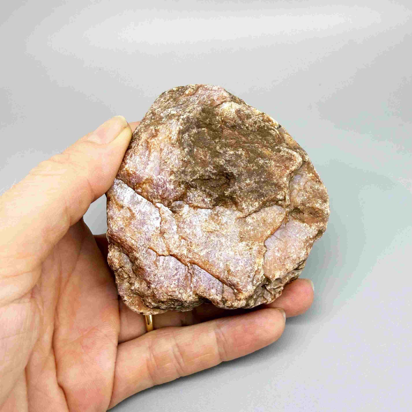 Natural ruby rough stone with purple-pink tones in host rock, uncut corundum specimen