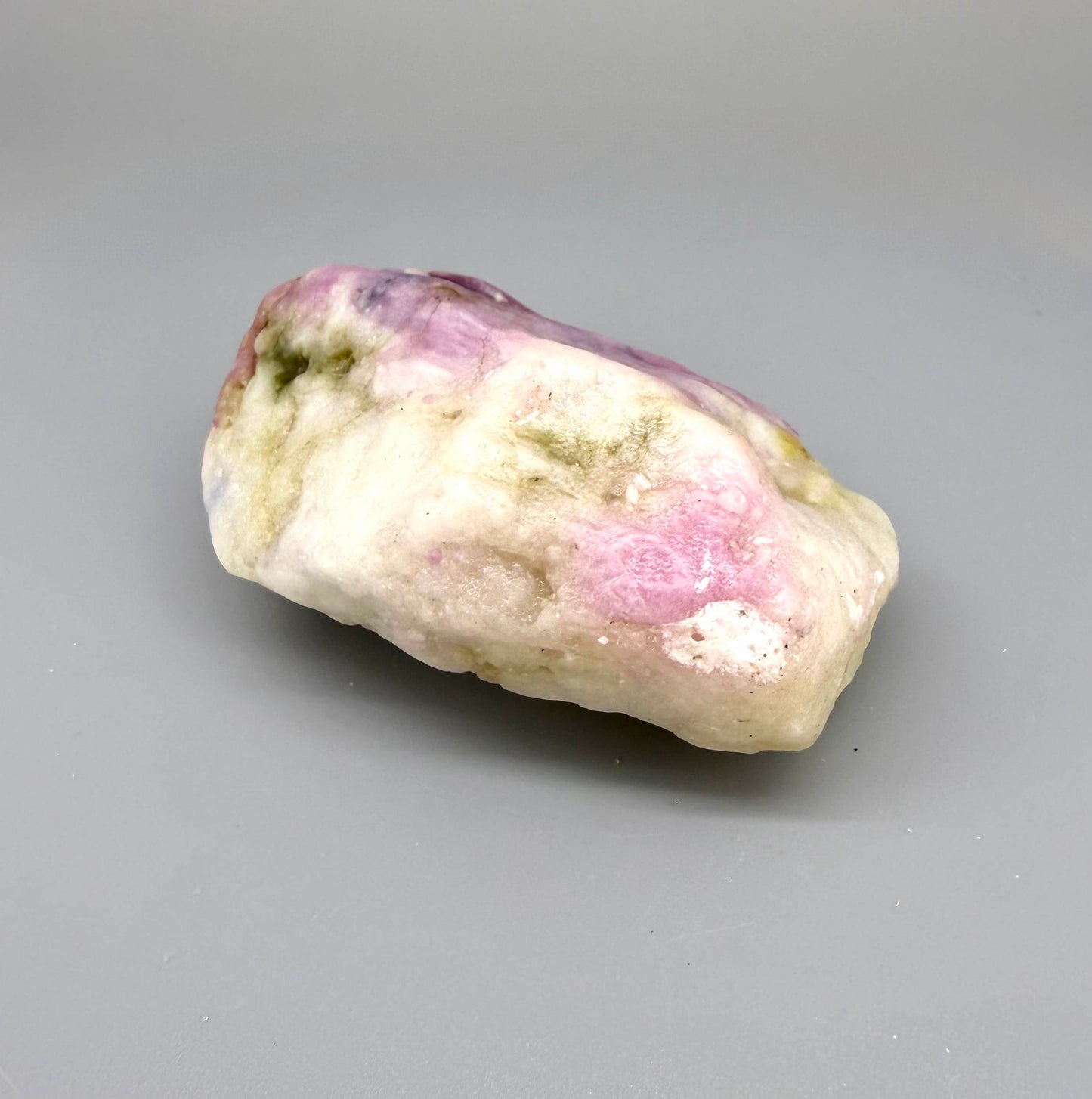 Natural ruby in creamy-white matrix, pink to purplish-pink rough corundum partially encased in host rock.