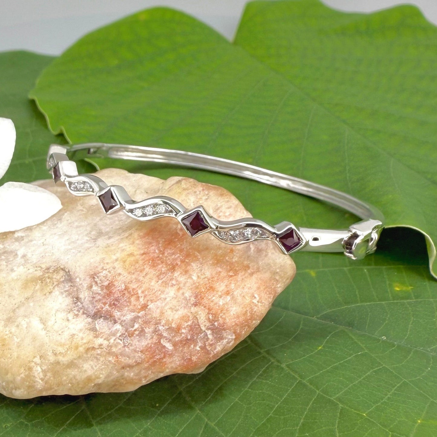 White gold plated silver bangle with natural rubies and cubic zirconia in a refined alternating design.