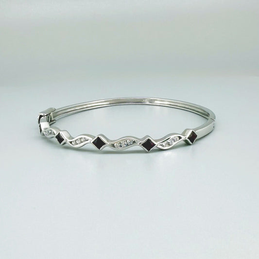 White gold plated silver bangle with natural rubies and cubic zirconia in a refined alternating design.