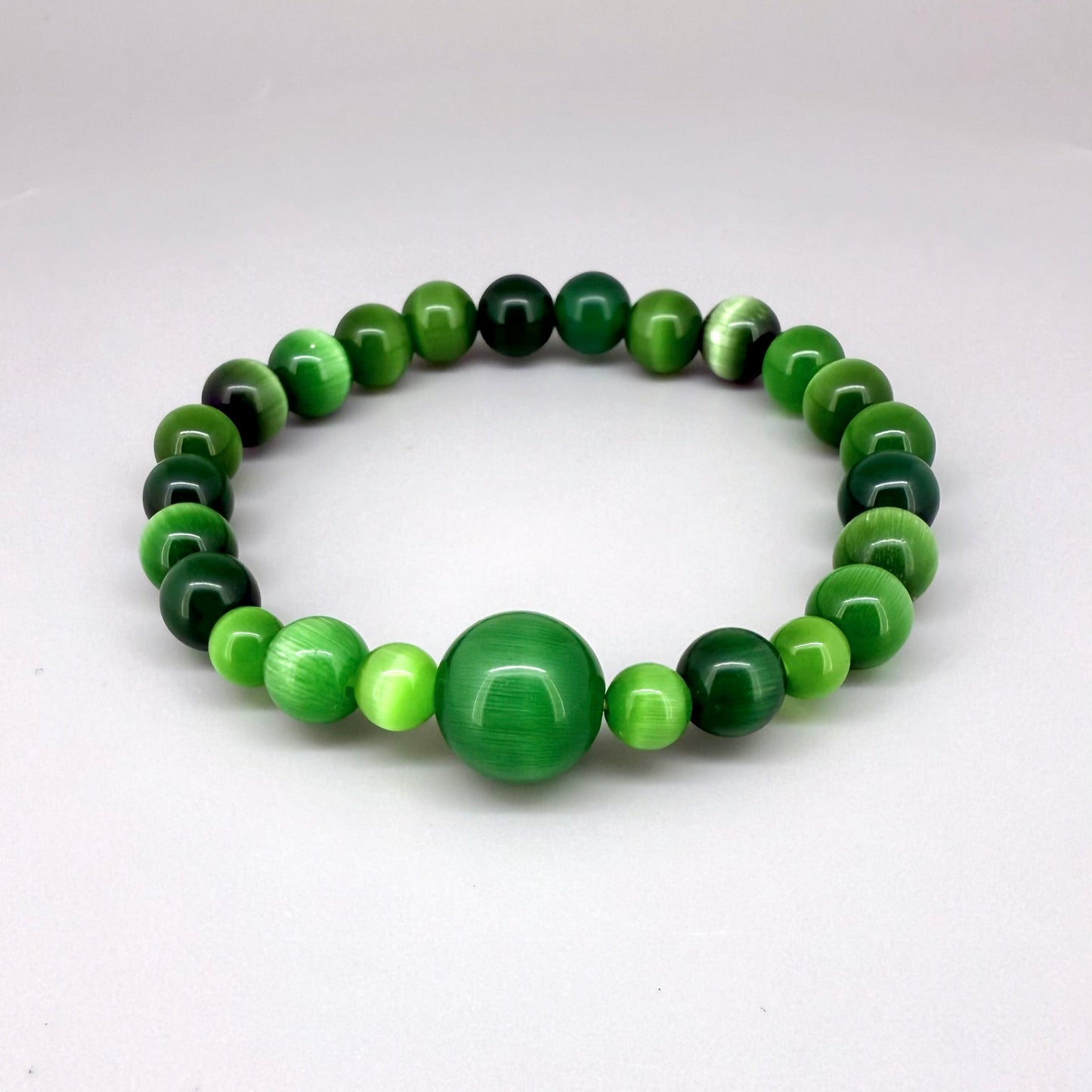 Green cat’s eye beaded bracelet, 18cm, shimmering green gemstone beads with one larger focal bead on elastic stretch band.