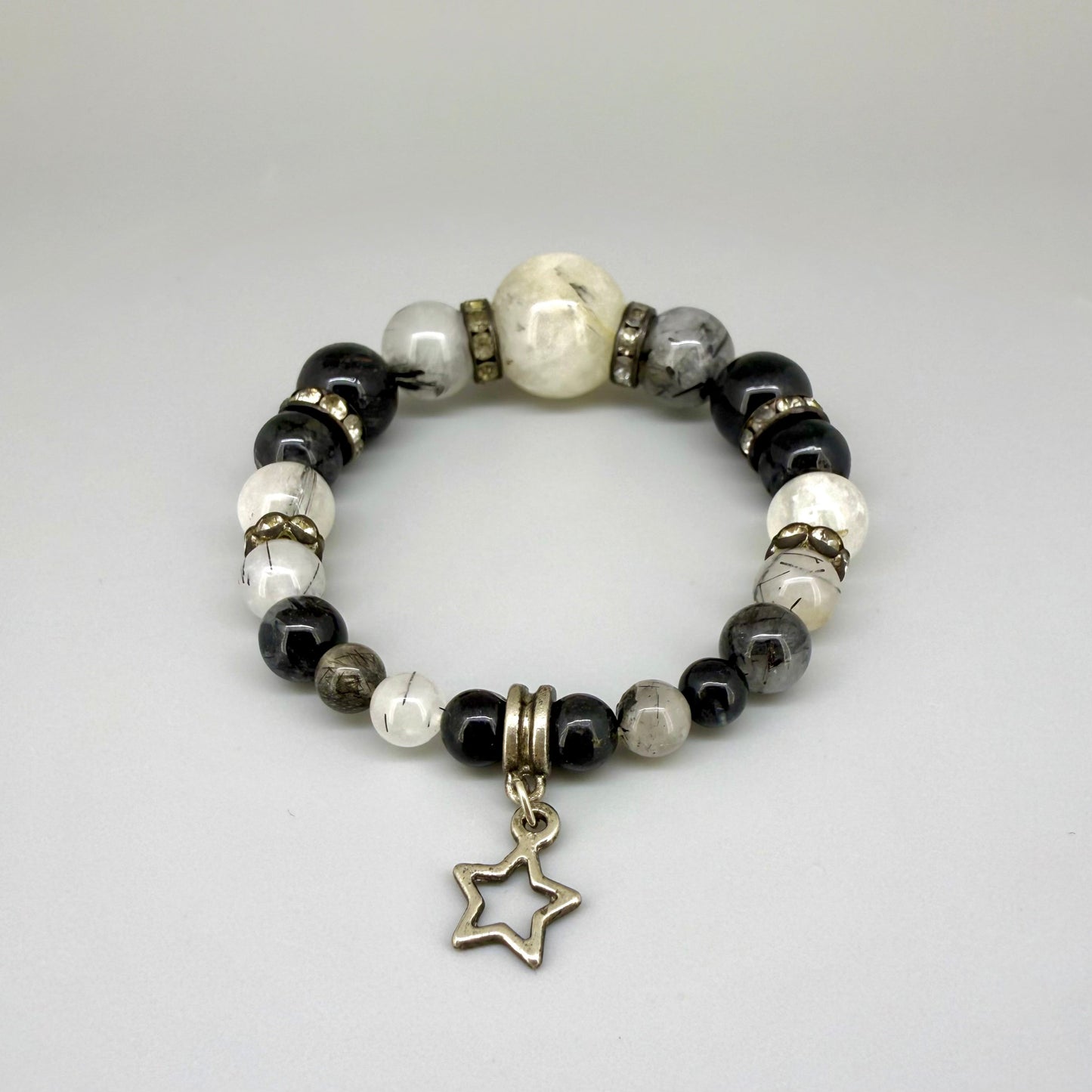 Rutilated quartz beaded bracelet, 18cm, black rutile inclusions with larger light bead and star charm on elastic stretch band.