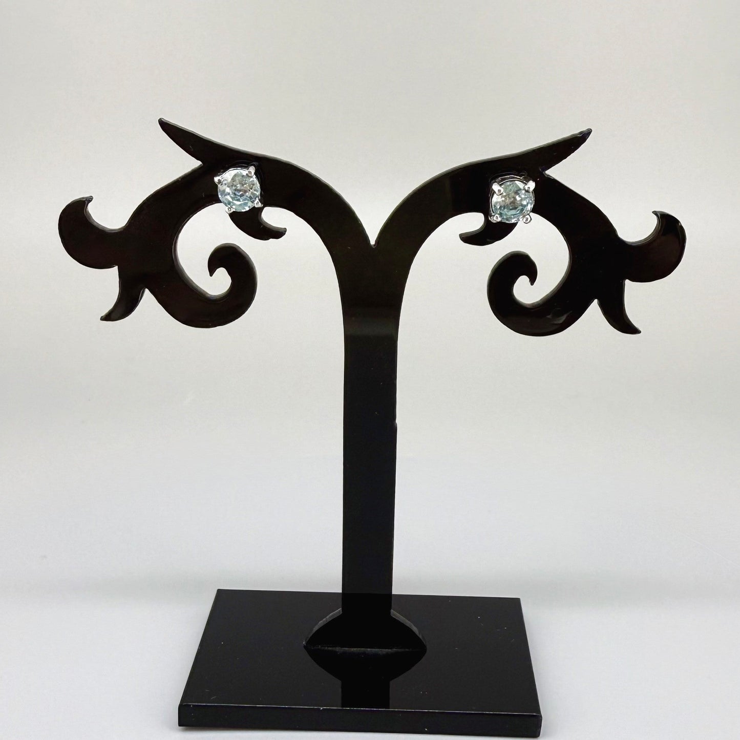 White gold plated sterling silver stud earrings featuring natural blue zircons with high brilliance and clarity.