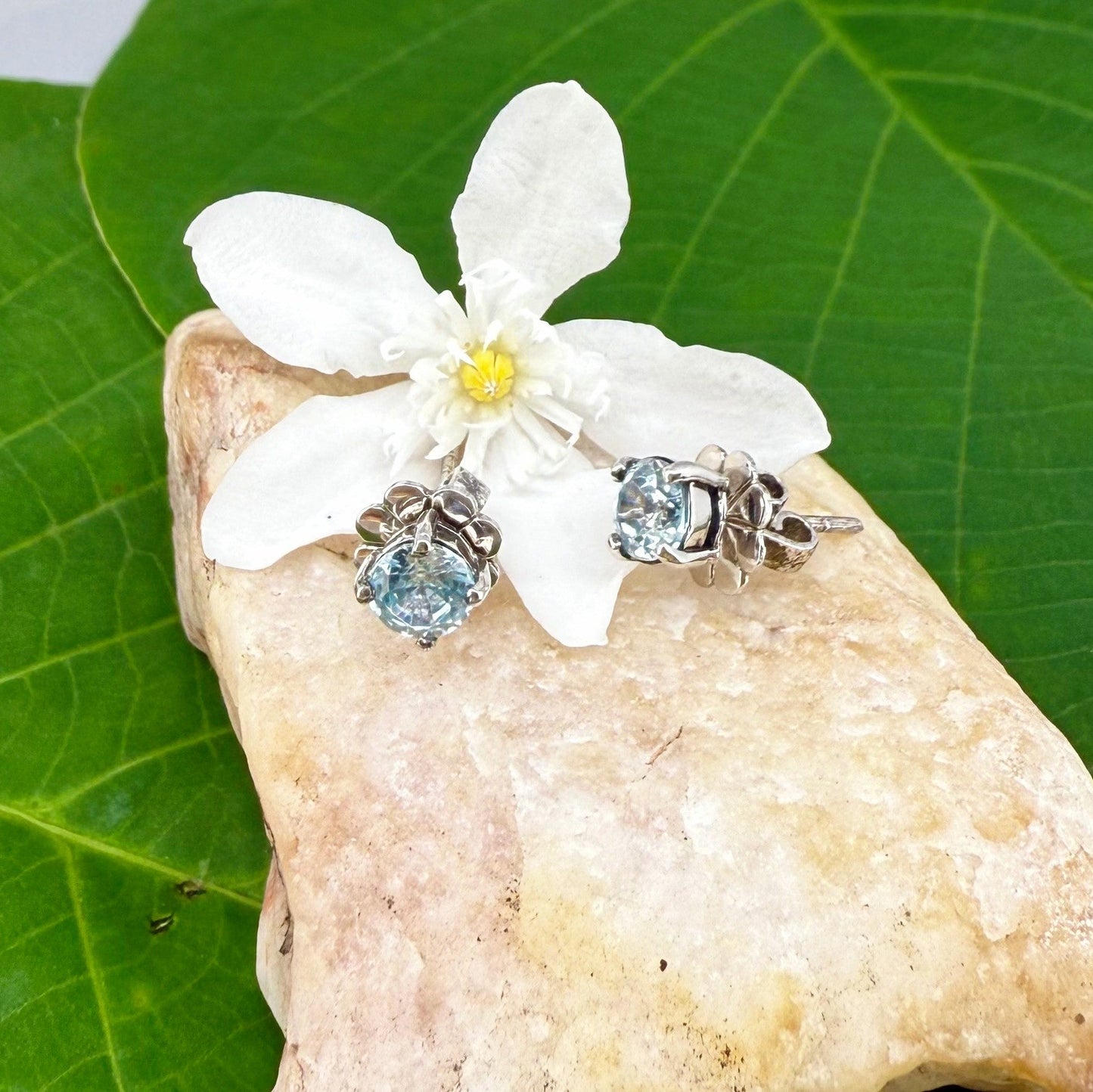 White gold plated sterling silver stud earrings featuring natural blue zircons with high brilliance and clarity.