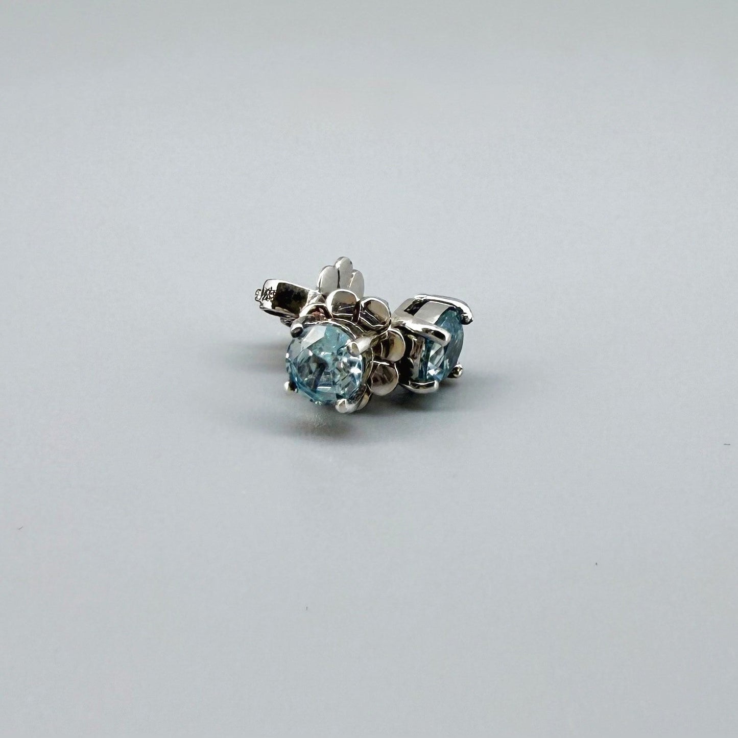 White gold plated sterling silver stud earrings featuring natural blue zircons with high brilliance and clarity.