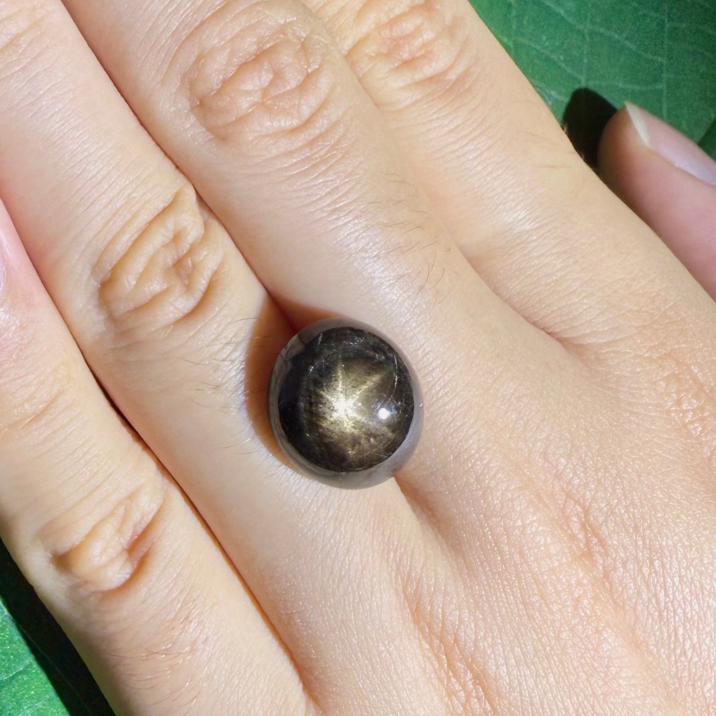 Golden-brown star sapphire cabochon, natural gemstone with visible asterism