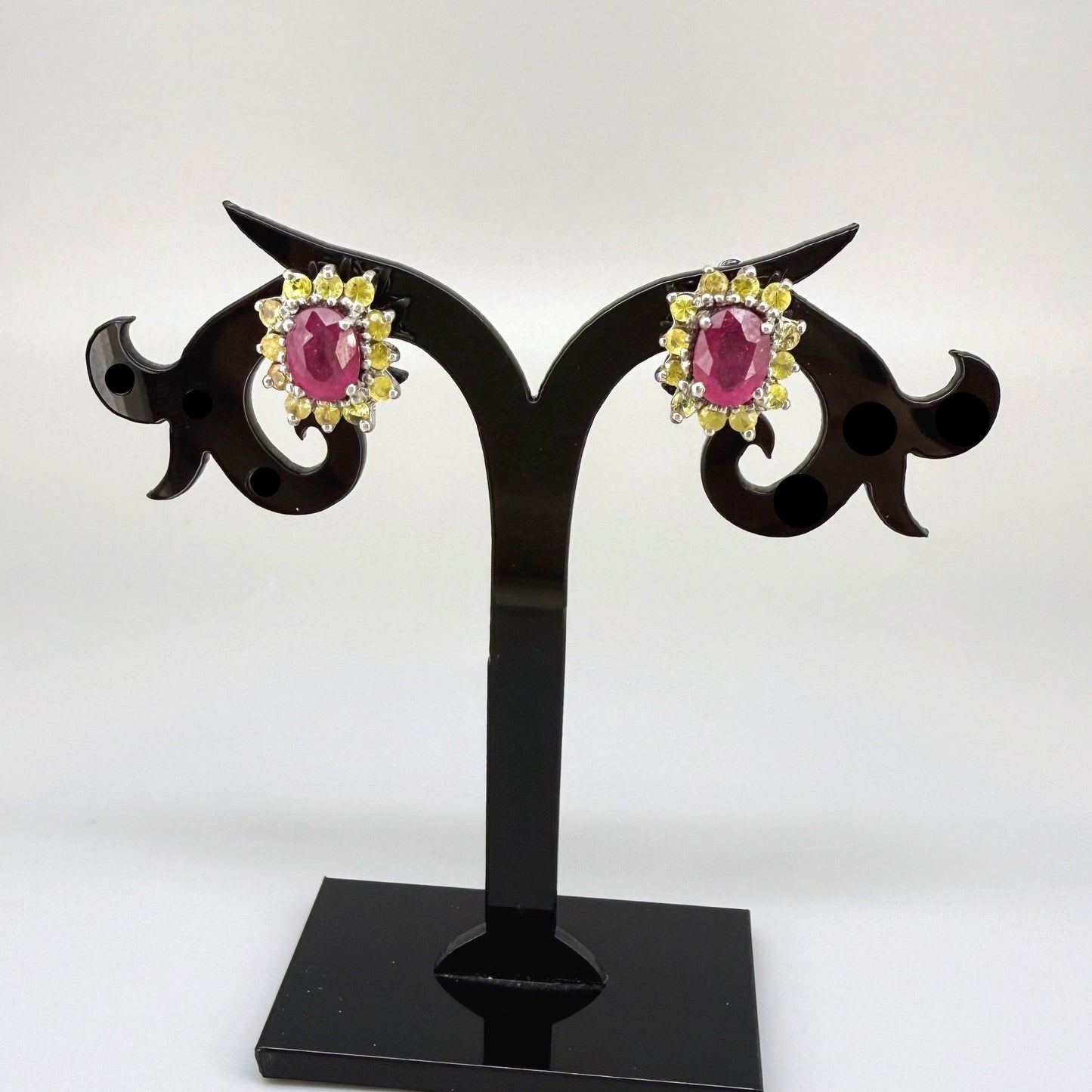 Ruby and yellow sapphire stud earrings in white gold plated sterling silver with butterfly backs.