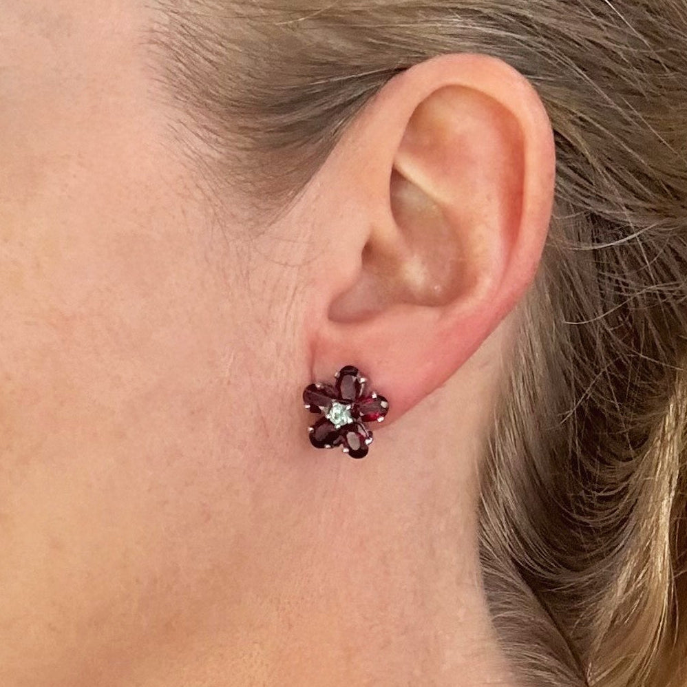 White gold plated silver floral earrings with 5.85 ct rubies and 0.32 ct sapphires; elegant red and blue gemstone flower design.