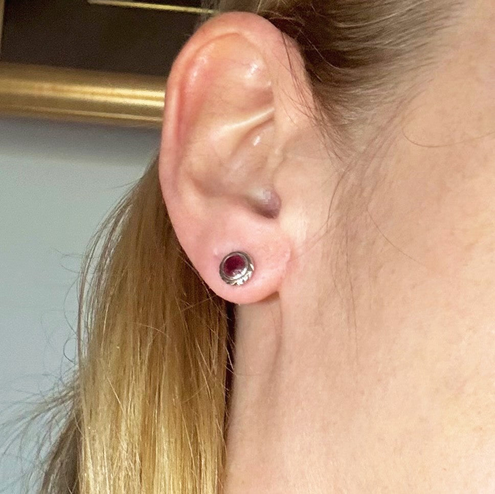 Ruby stud earrings in white gold plated sterling silver with butterfly backs.