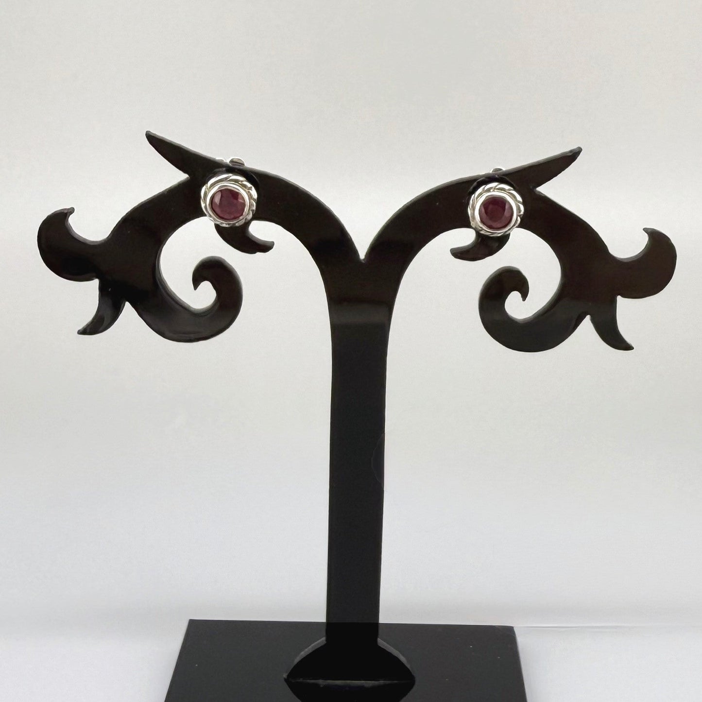 Ruby stud earrings in white gold plated sterling silver with butterfly backs.