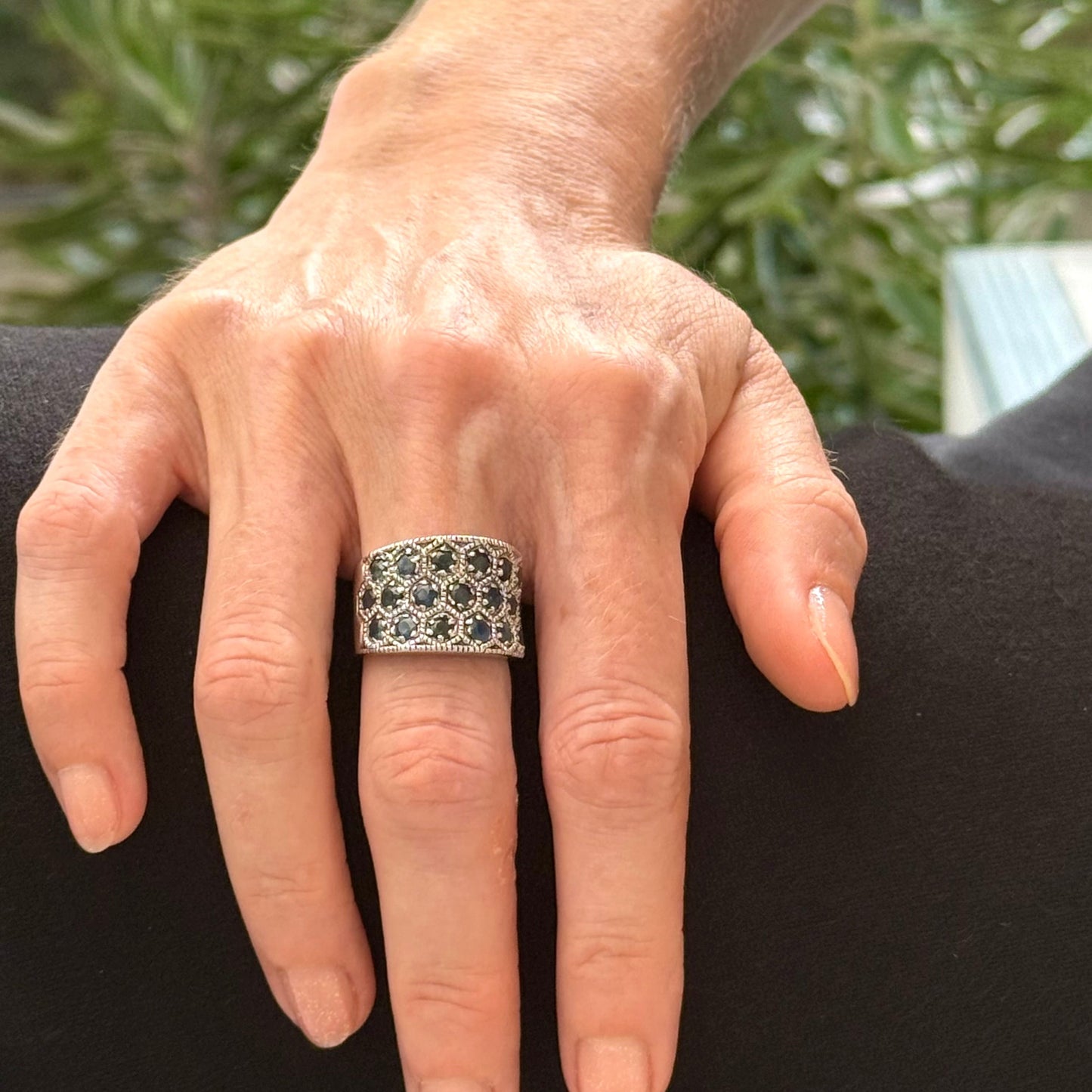 Wide band ring with light blue sapphires set in white gold plated sterling silver, reflecting soft blue brilliance with timeless elegance.