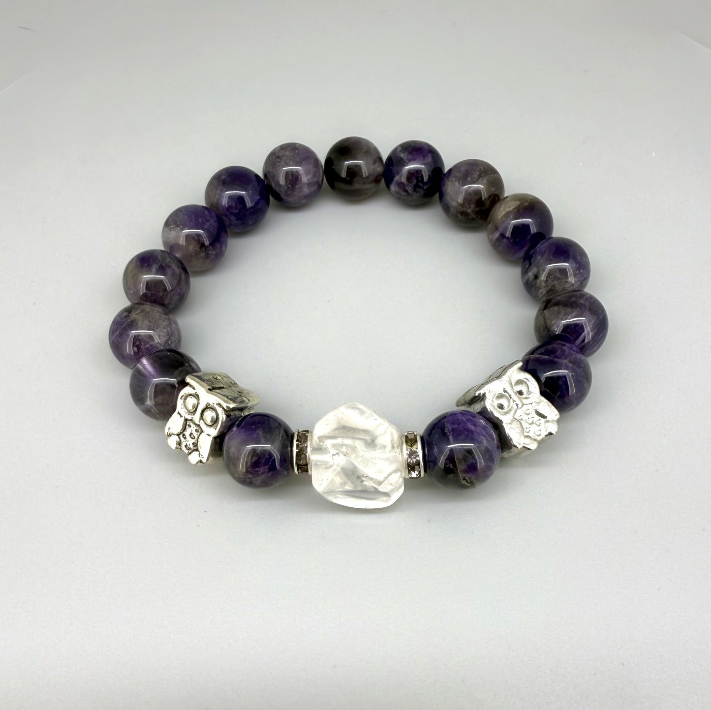 Amethyst beaded bracelet, 18cm, violet gemstone beads with large clear white focal stone and two owl accents on elastic stretch band.