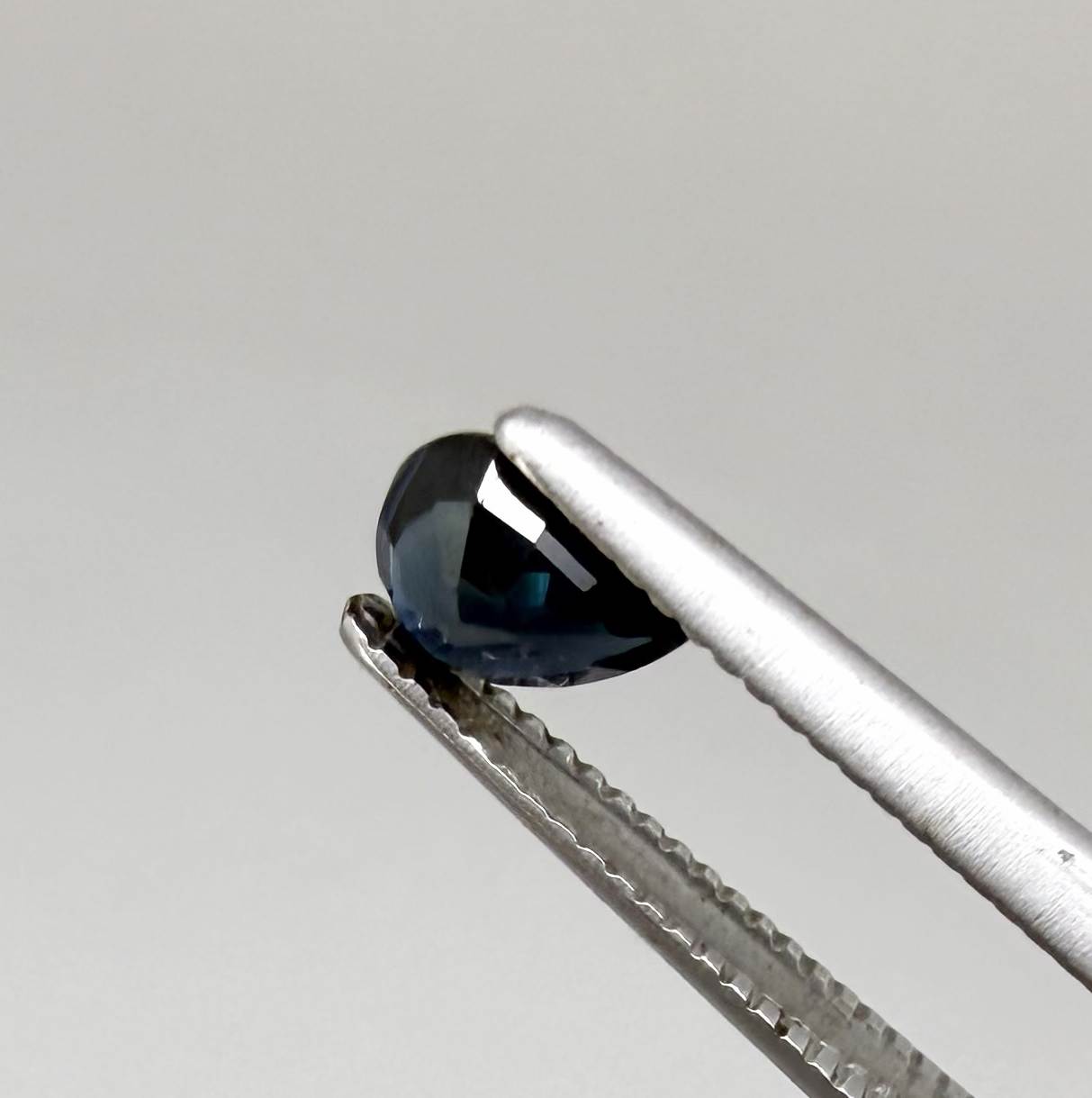 Dark slate blue sapphire from Bangkaja, Thailand in pear cut with deep inky blue tone and natural brilliance.