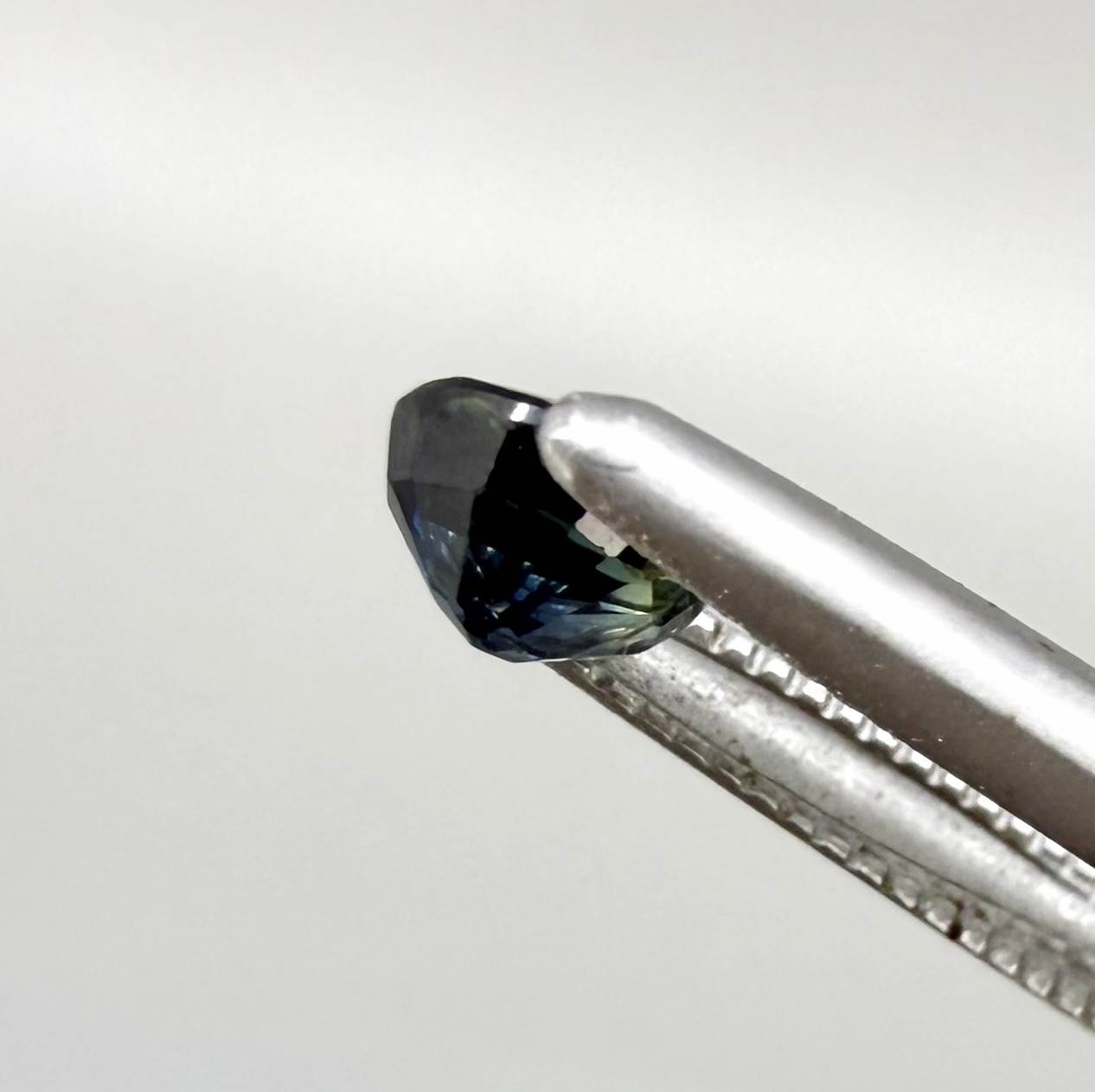 Pear-cut deep teal sapphire from Bangkaja, Thailand with blue-green tones, natural faceted gemstone.