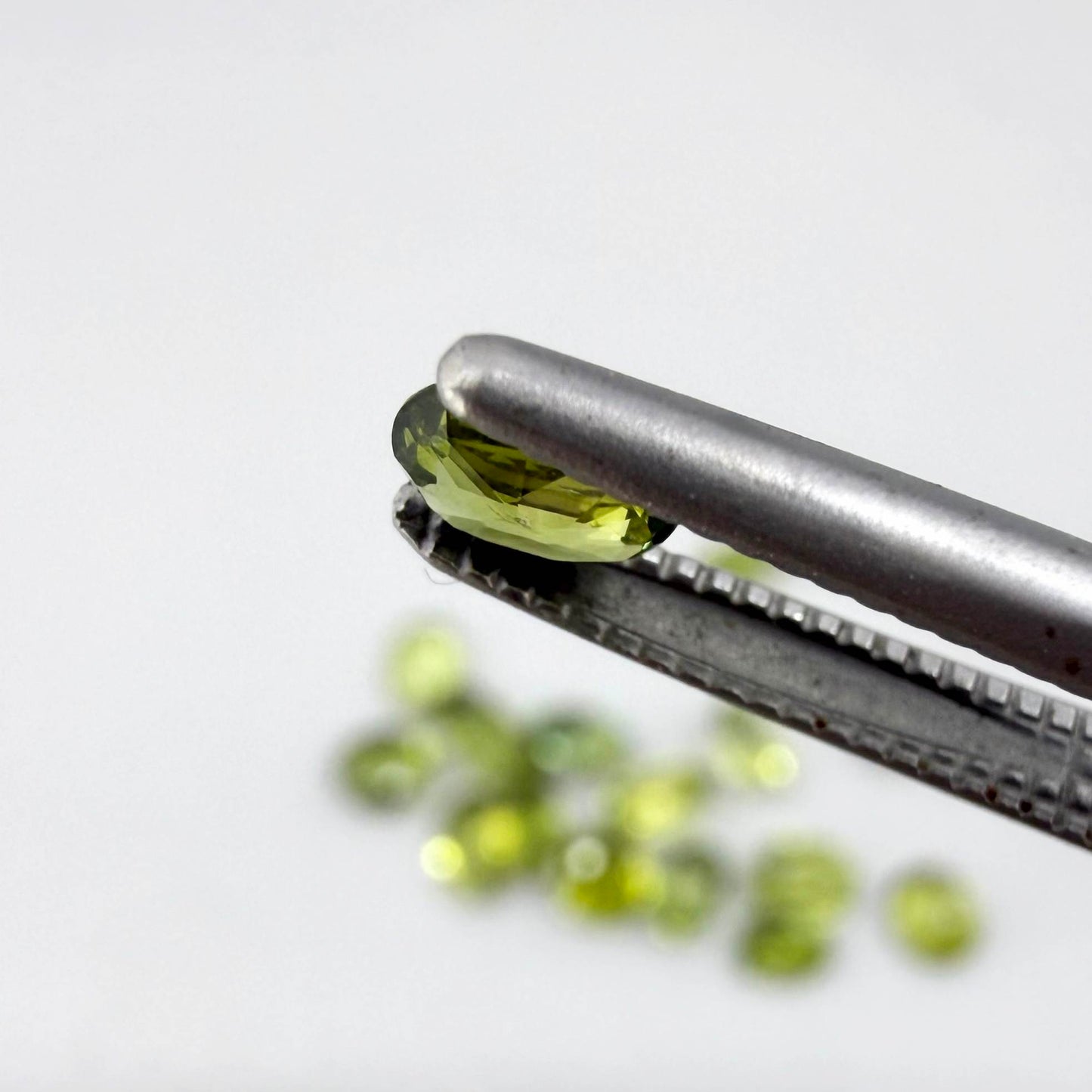 Small parcel of lime green sapphires from Bangkaja, Thailand in oval mixed cuts, natural faceted gemstones.