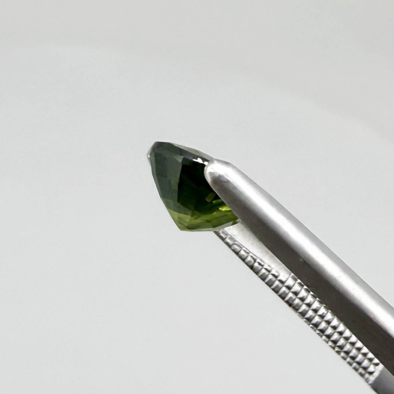 Oval-cut vivid yellowish-green sapphire from Bangkaja, Thailand, natural faceted gemstone with bright lime green tones.