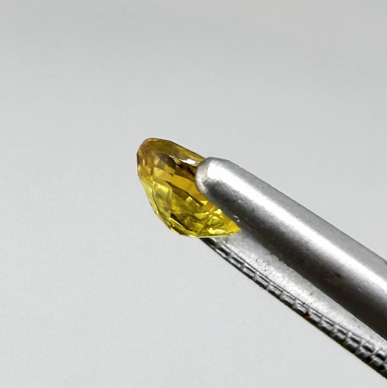 Oval golden yellow sapphire from Bangkaja, Thailand with vivid natural color and bright brilliance.
