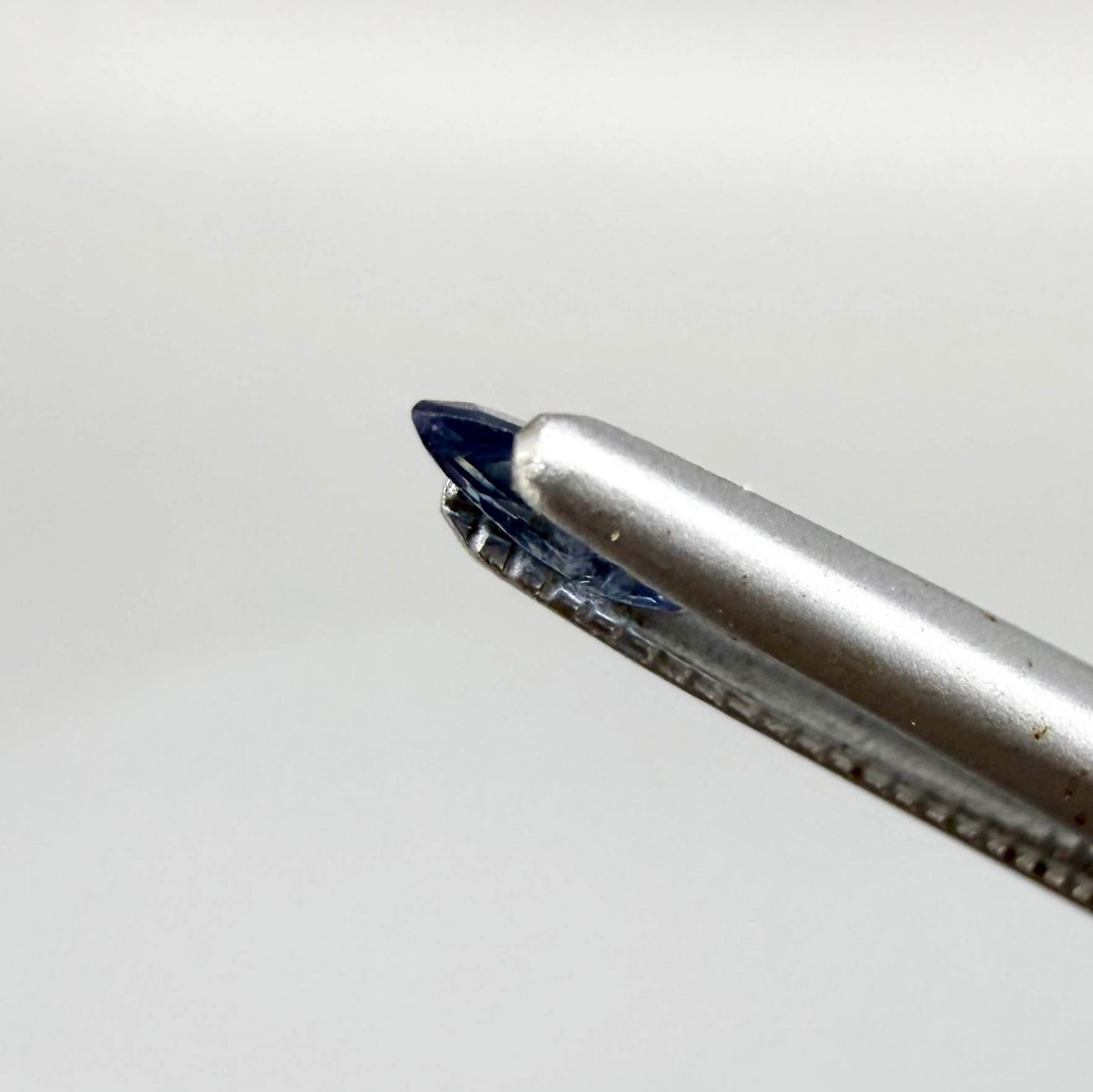 Marquise dark steel blue sapphire from Bangkaja, Thailand with natural zoning and deep blue tone.