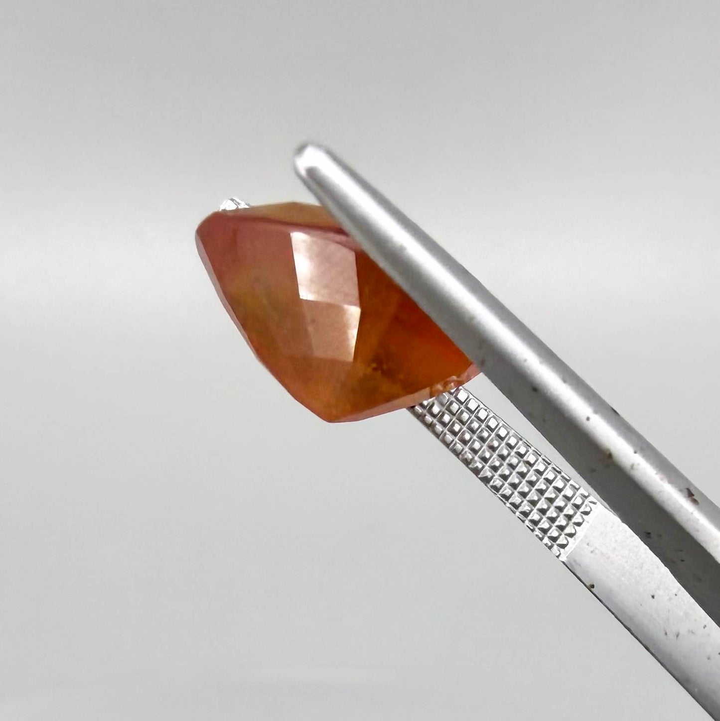 Heart cut orange sapphire from Africa, 6.76ct, with vivid orange to reddish-orange color, visible natural inclusions and a transparent to slightly silky appearance.
