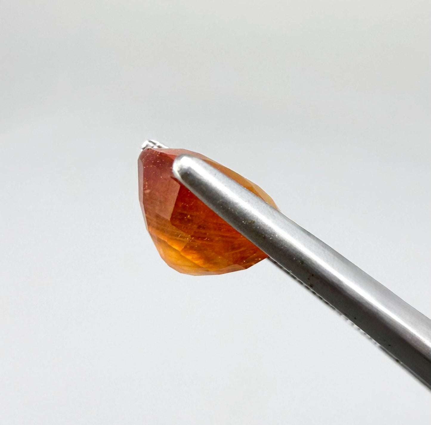 Oval orange sapphire from Africa, 4ct, with vivid orange to mandarin color, visible natural inclusions and a transparent to slightly silky appearance.