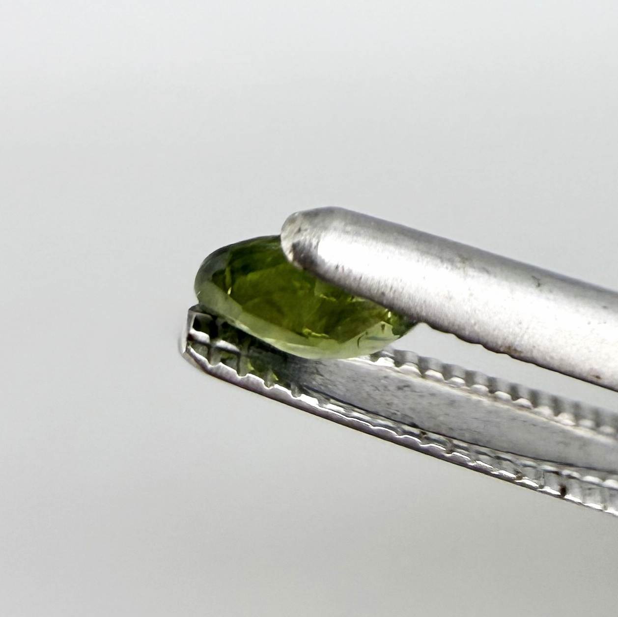 Oval green sapphire from Thailand, 0.29ct, unheated, with fresh olive-green color, eye-clean clarity and a transparent appearance.