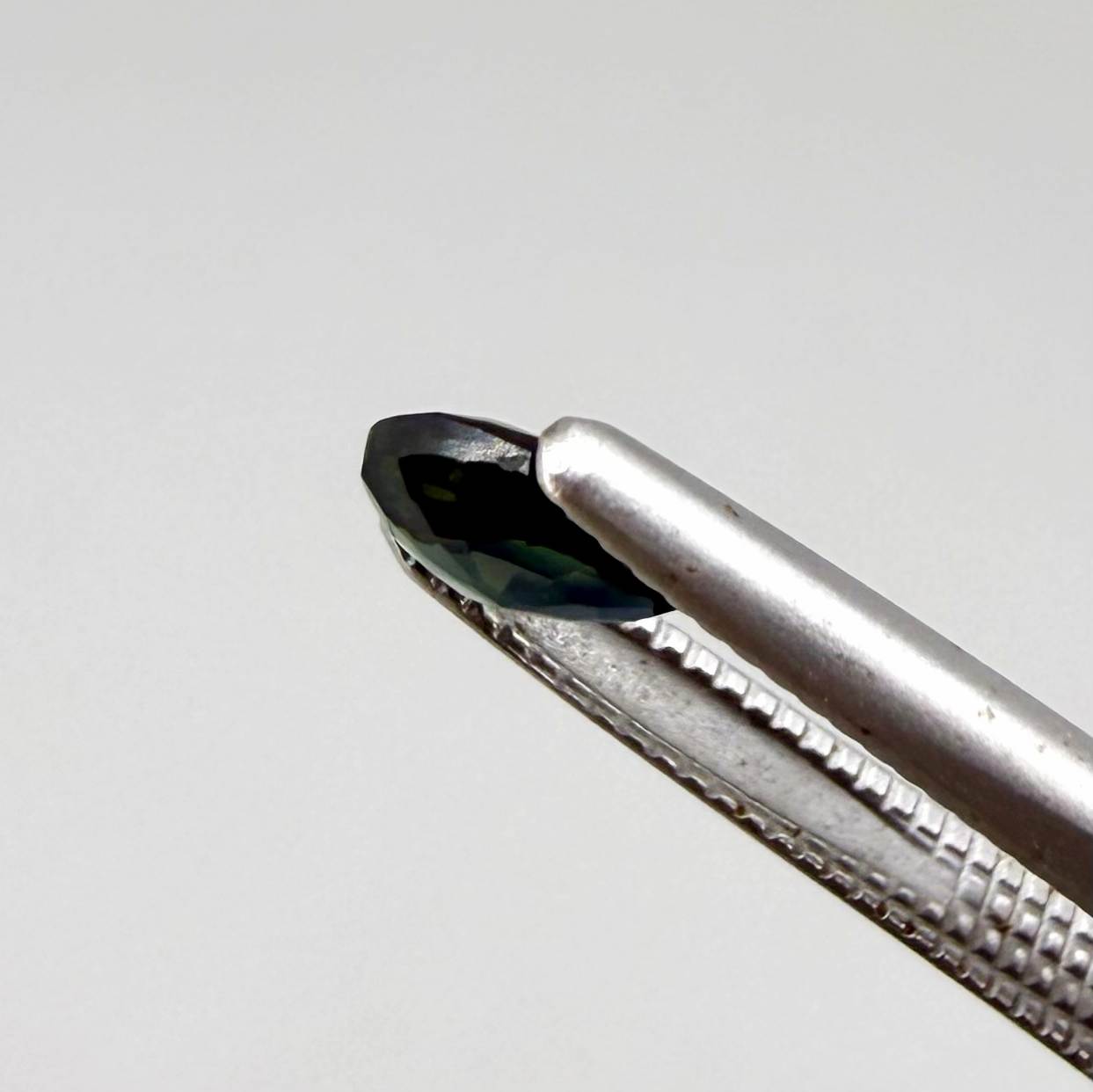 Olive green pear-shaped Laos sapphire weighing 0.39 ct, heated and eye-clean.