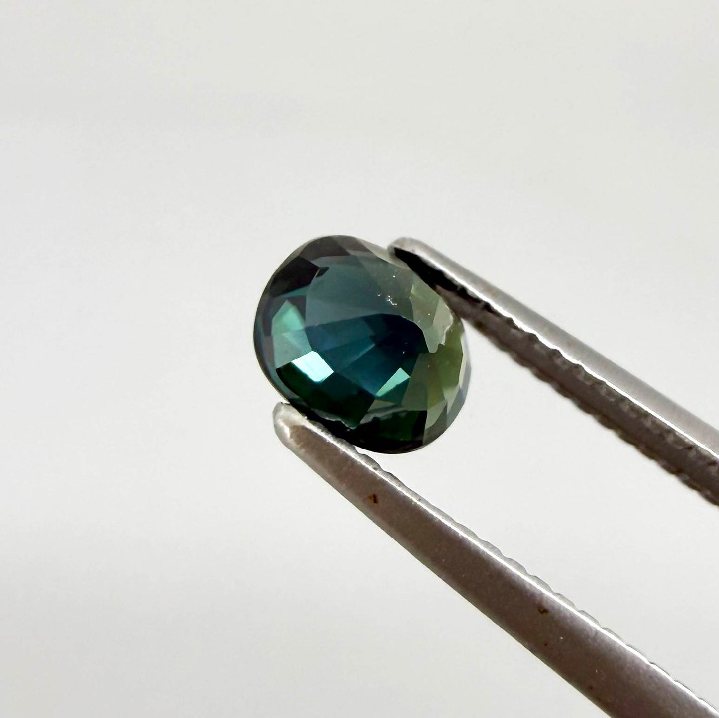 0.66 ct teal Laos sapphire in oval cut, heated and eye-clean with vivid blue-green color.