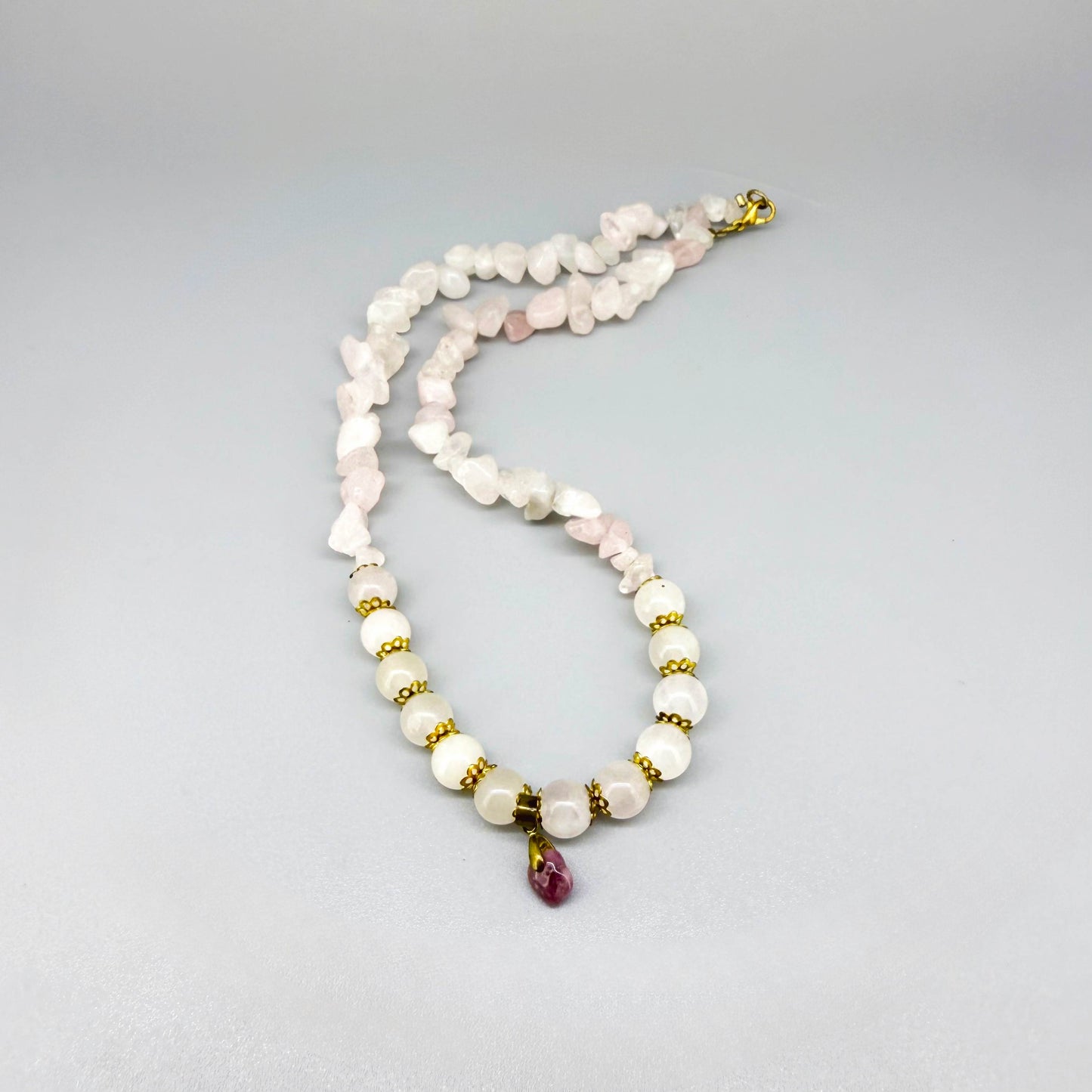 Rose quartz jewelry set with necklace, bracelet, and earrings in soft pink and gold tones, handcrafted with natural rose quartz beads.