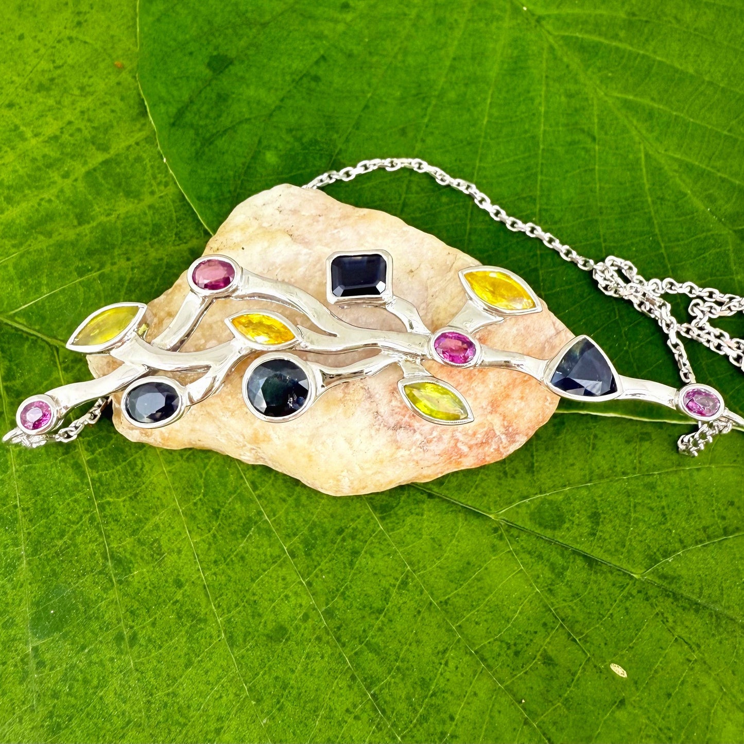 Handmade necklace in white-gold-plated silver featuring 13.89 ct natural sapphires and tourmalines in multicolor hues — artistic design with integrated chain.