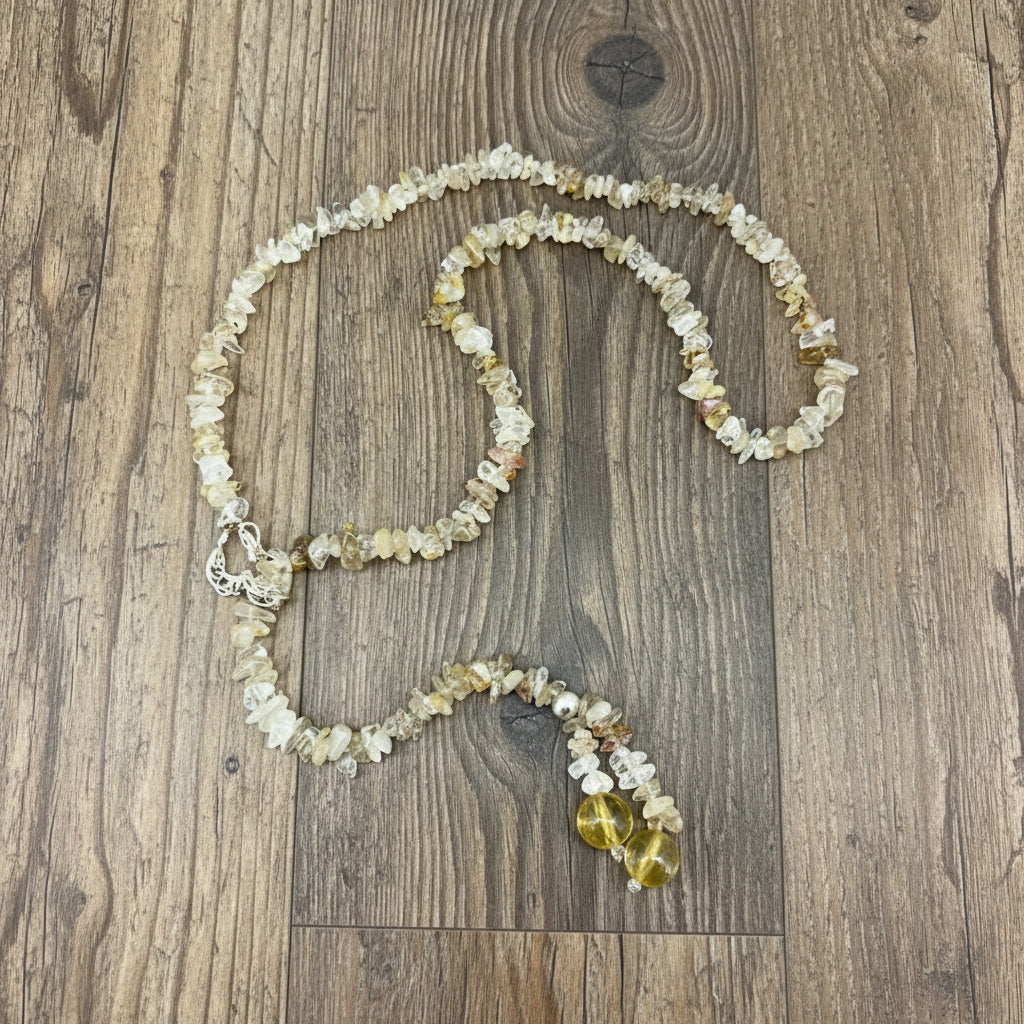 Golden rutilated quartz necklace with polished beads and a stainless-steel loop closure, styled as a drop-through design.