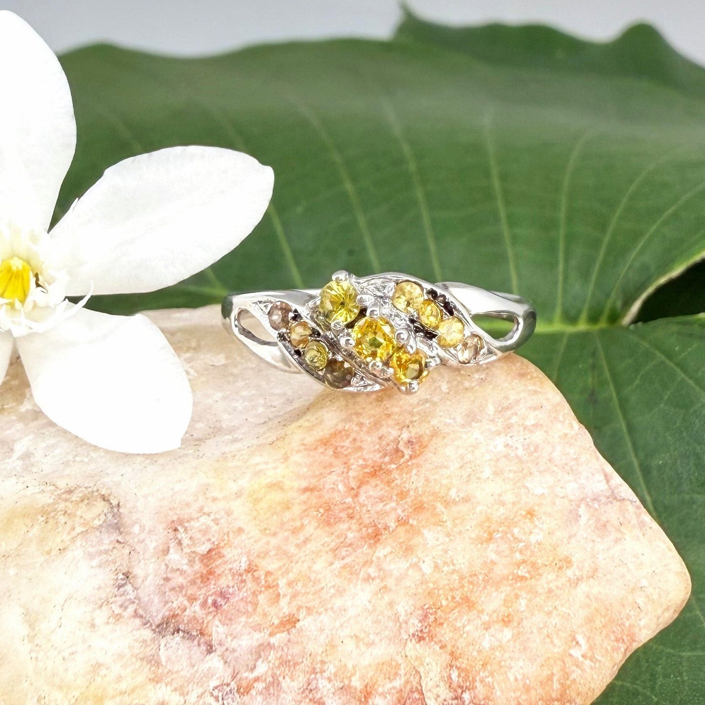 White gold plated sterling silver ring featuring two marquise-cut yellow sapphires in an elegant bypass setting.