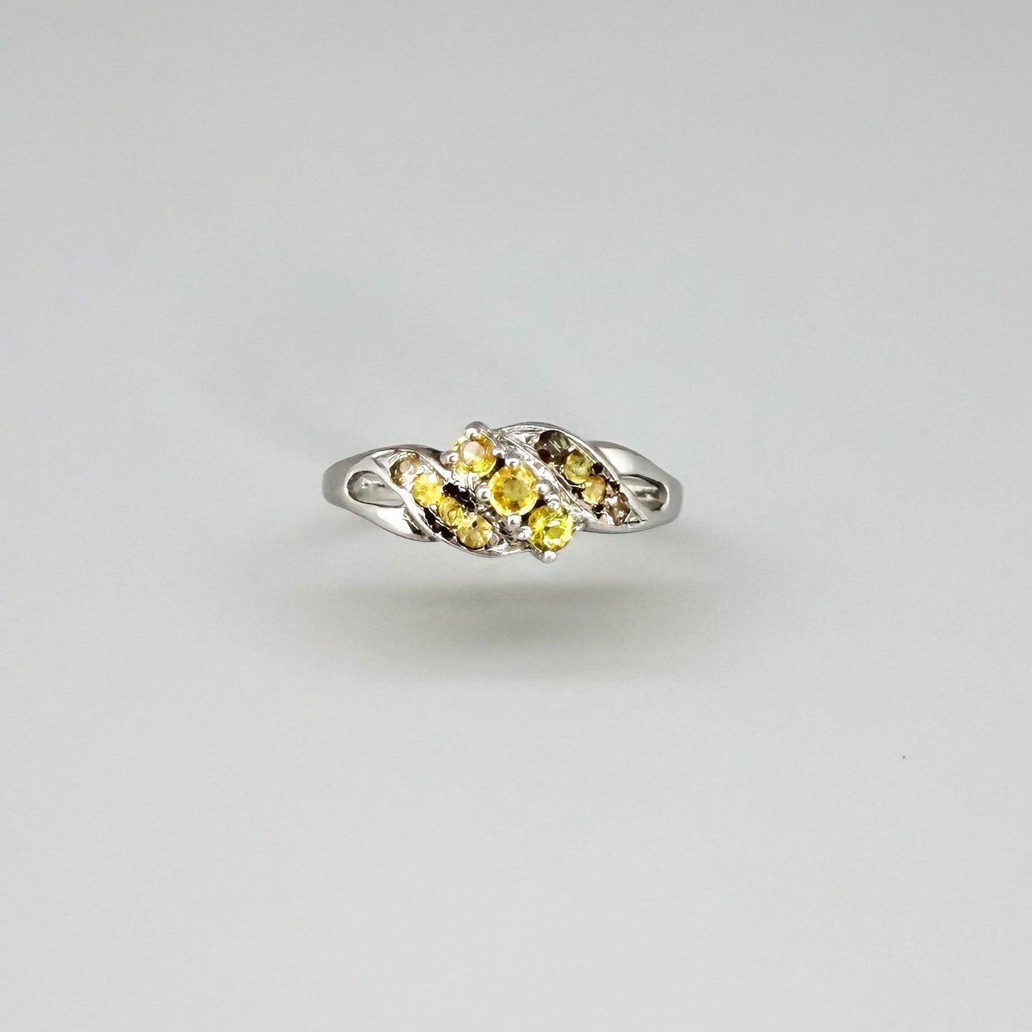 White gold plated sterling silver ring featuring two marquise-cut yellow sapphires in an elegant bypass setting.