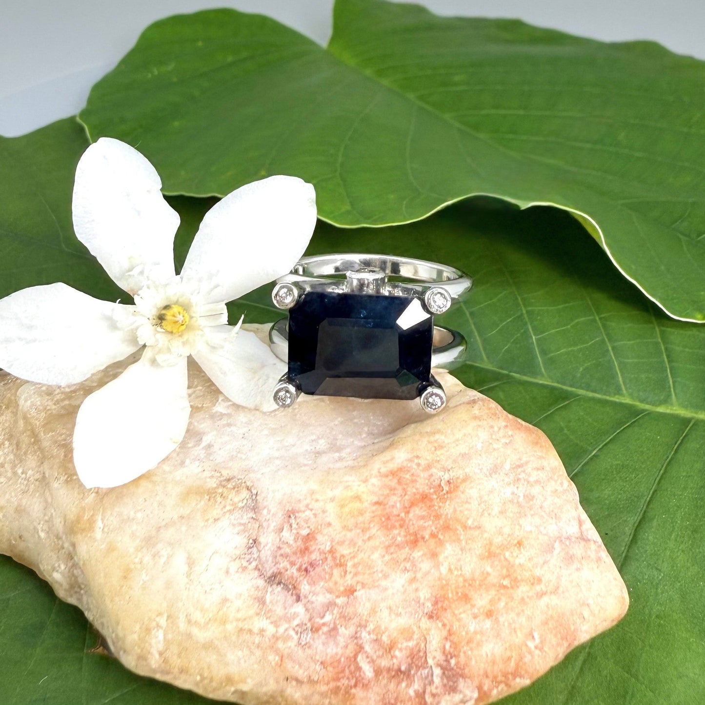 Emerald-cut sapphire ring in white gold plated sterling silver, featuring a natural deep blue gemstone in a bold and elegant solitaire design.