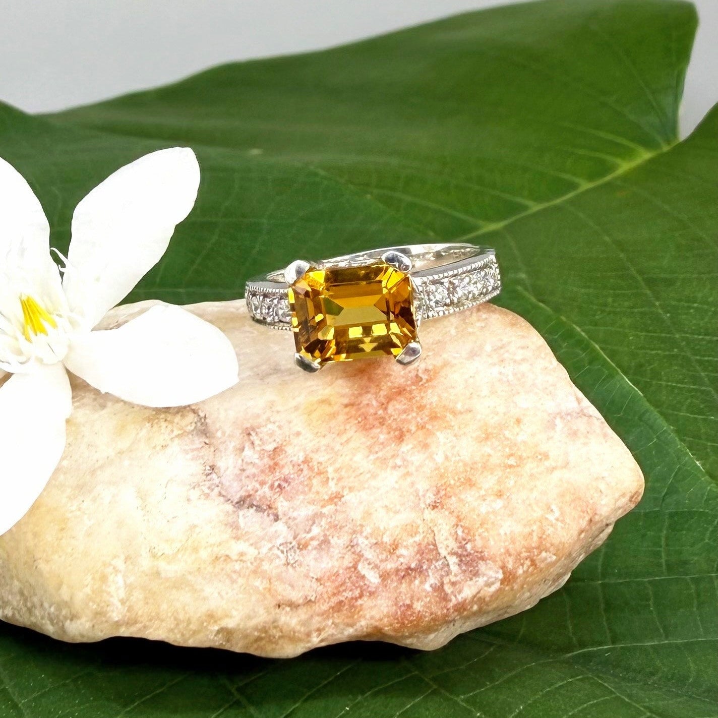Citrine and CZ ring in white gold plated sterling silver, featuring a faceted golden gemstone framed by clear cubic zirconia, elegant and radiant design.
