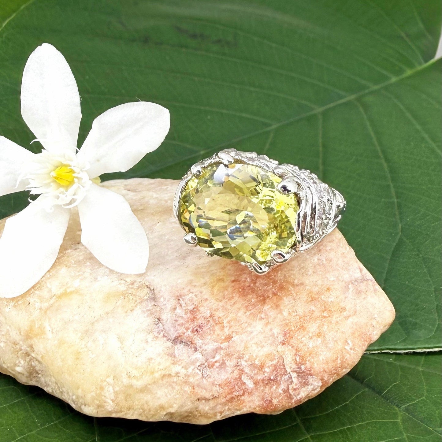 Lemon quartz ring in white gold plated sterling silver, featuring a faceted oval-cut yellow-green gemstone in an ornate vintage-inspired setting.