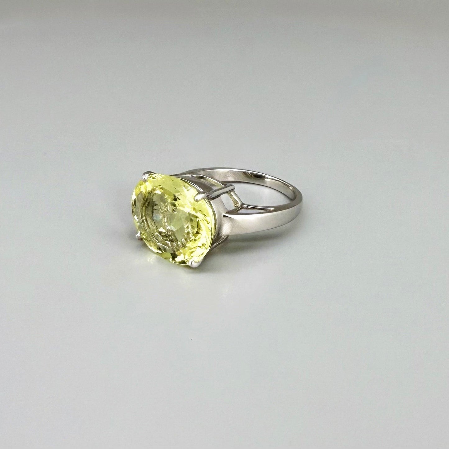 Lemon quartz solitaire ring in white gold plated sterling silver, featuring a large faceted yellow-green gemstone, bold and elegant design.