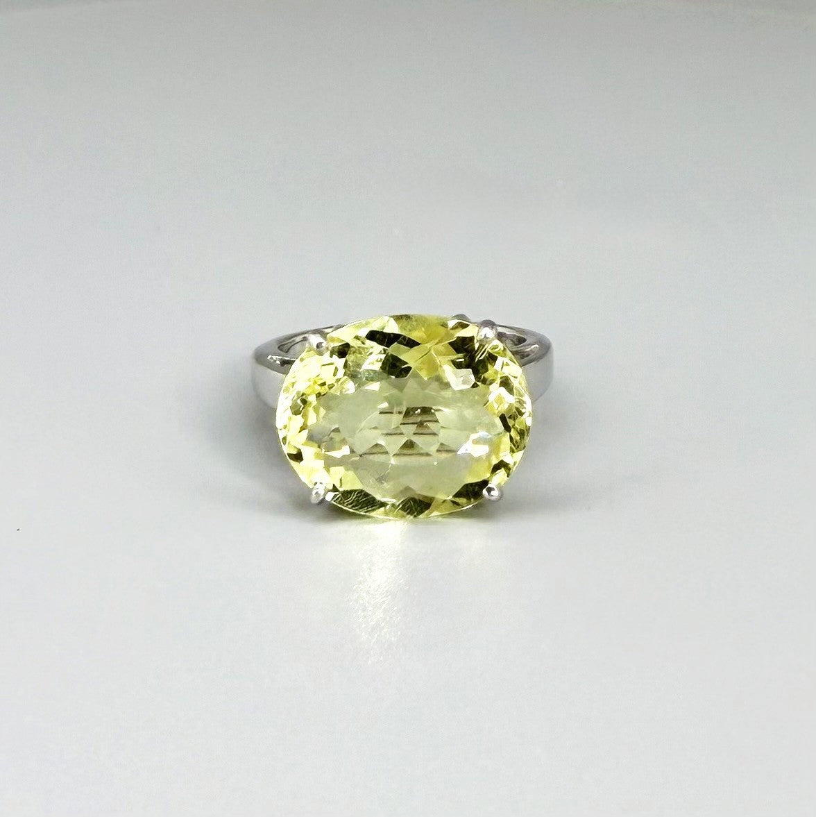 Lemon quartz solitaire ring in white gold plated sterling silver, featuring a large faceted yellow-green gemstone, bold and elegant design.