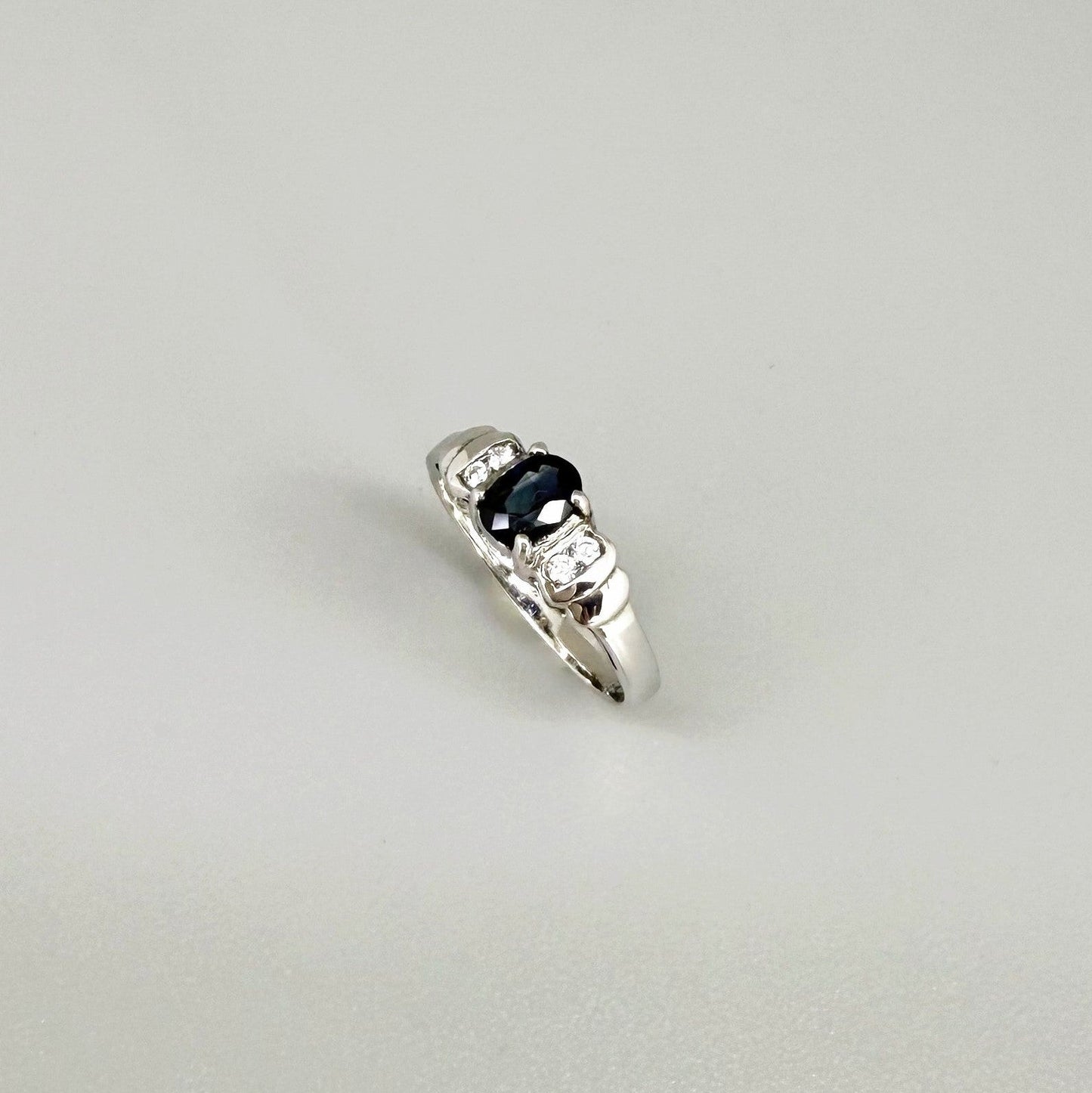 Sapphire and CZ ring in white gold plated sterling silver on neutral background